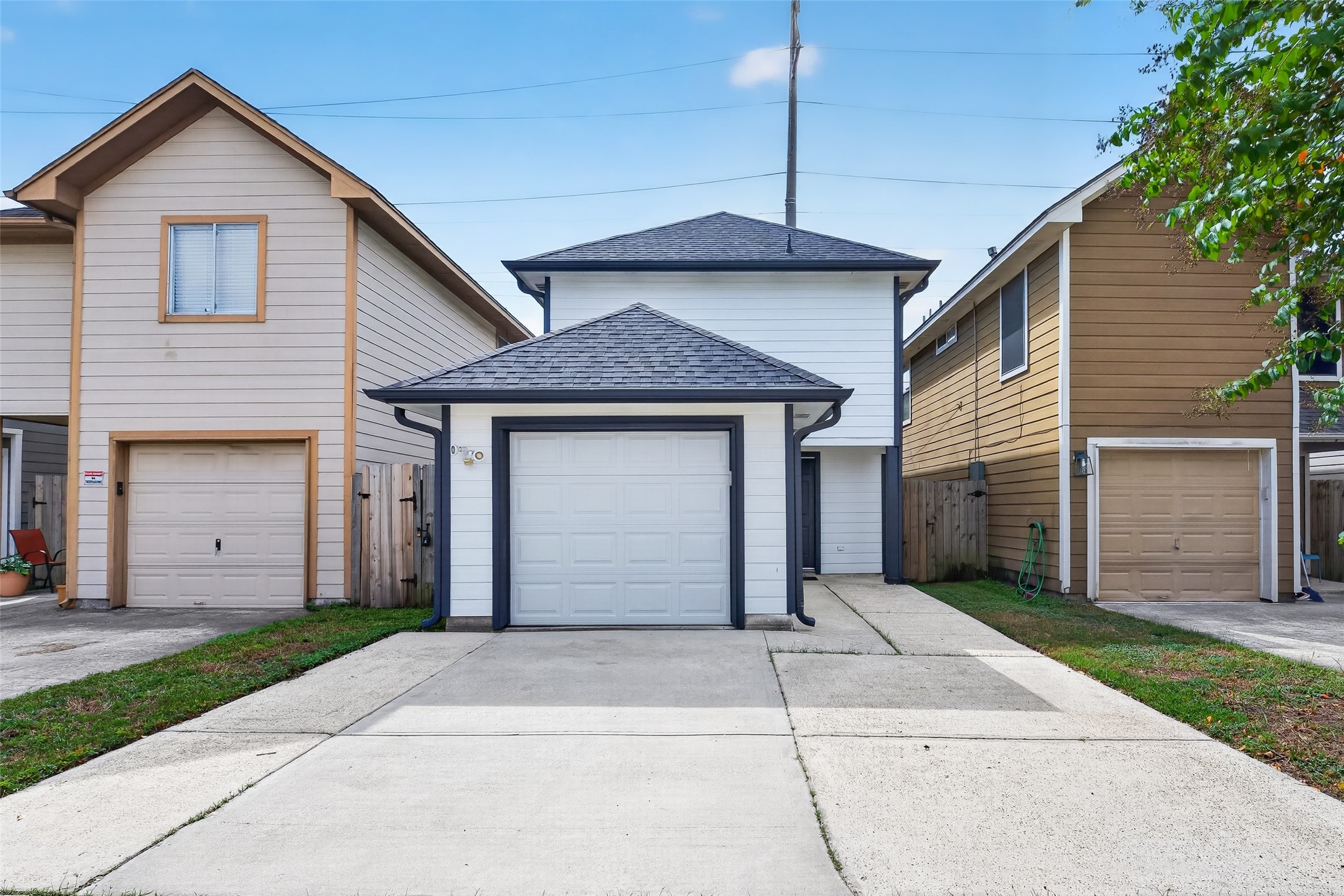 Back of house with one care garage and additional parking.