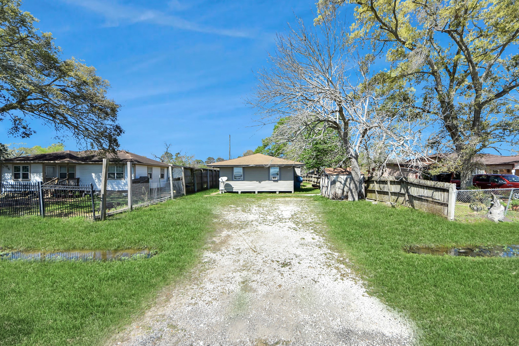 exterior view from the road showing the driveway leading up to the parking area