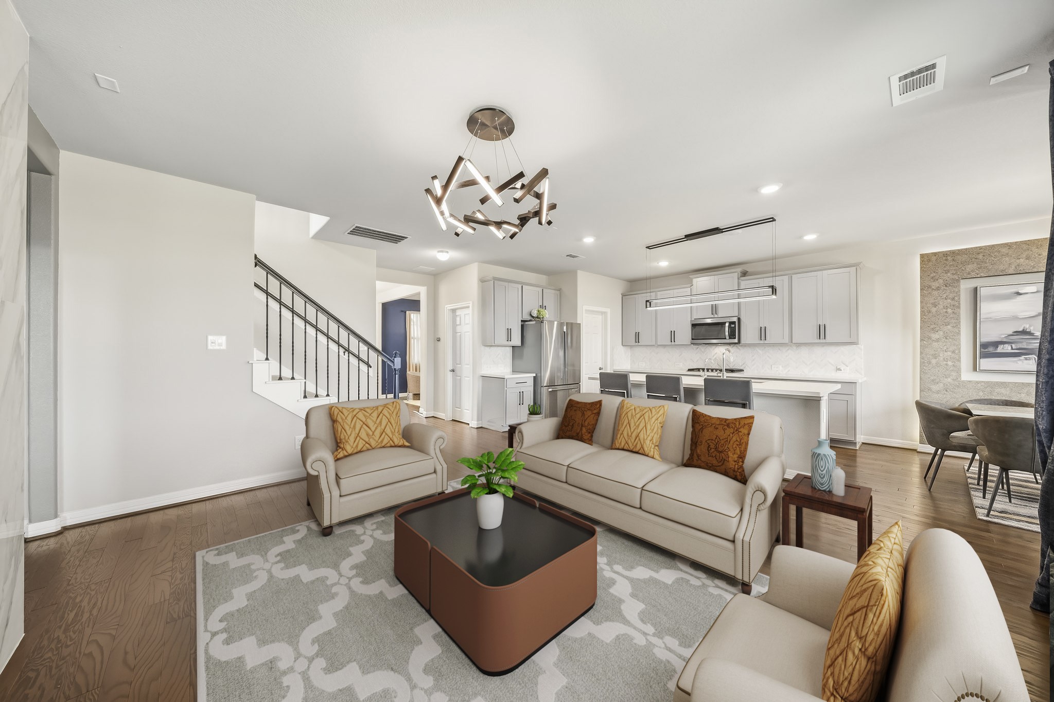 Virtually Staged: This spacious living room offers a bright, inviting setting with warm wood flooring, recessed lighting, and a contemporary statement light fixture. The generous layout provides ample room for multiple seating arrangements, making it ideal for both relaxing and entertaining.