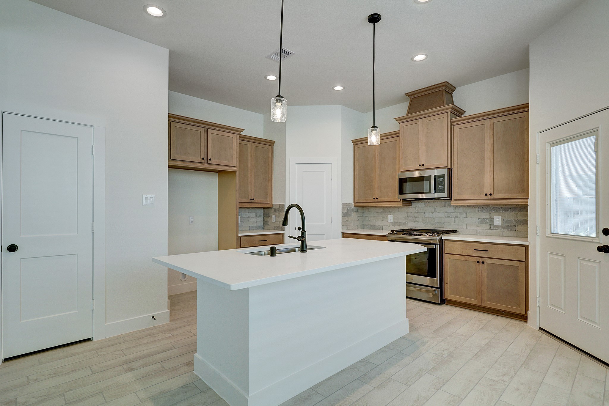 Beautiful kitchen with quartz island and pendant lighting.