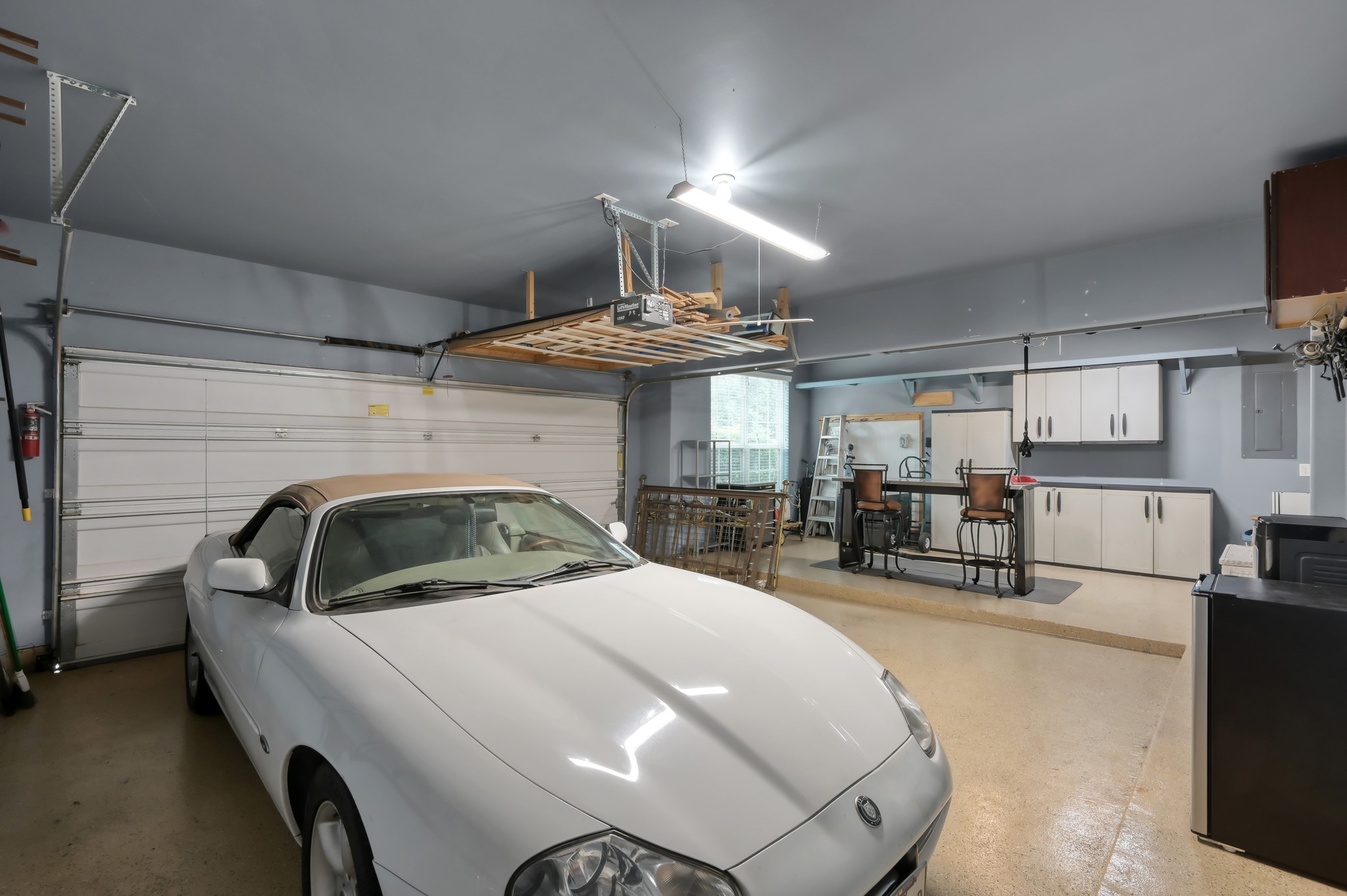 Oversized garage setup with epoxy-style flooring, built-in cabinetry, workshop space, hanging storage, and room for your toys, tools, and projects. A rare bonus area thats both functional and organized, with extra space for entertaining or hobbies.  It is also possible to put in a garage door and using the space for a extra vehicle!