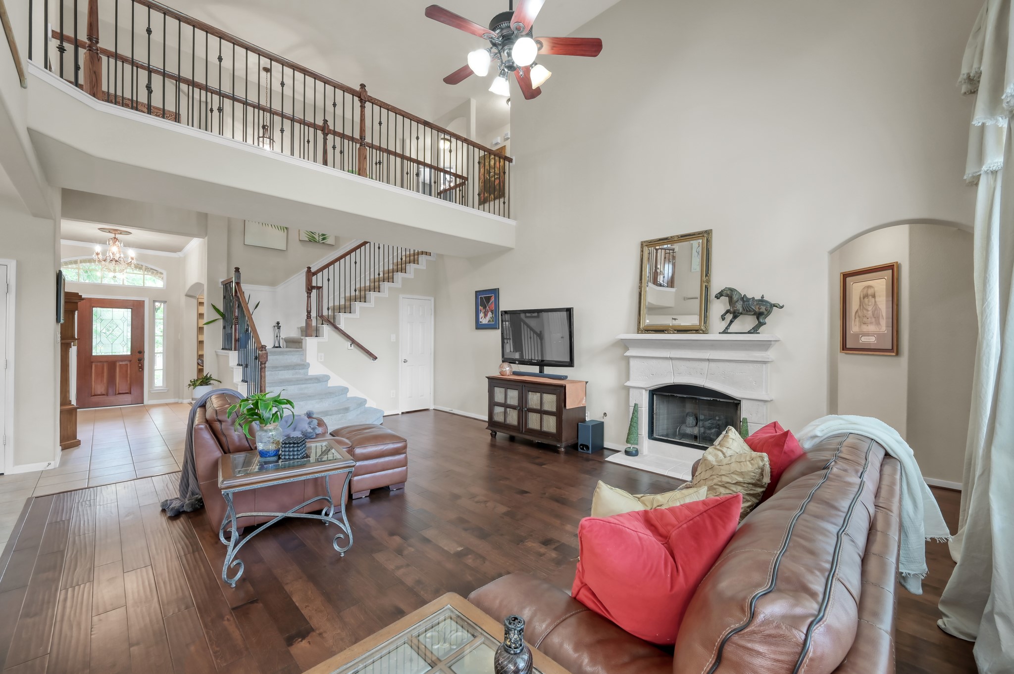 Relax in this warm and inviting livingroom complete with a cozy fireplace, gorgeous flooring, and expansive open views to the upstairs landing and entryway.