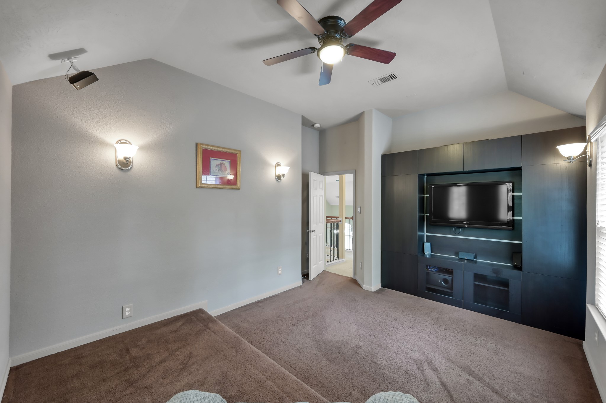 Dedicated media room with built-in entertainment center and elevated seating platform, perfect for movie nights, gaming, or relaxing with family and friends.