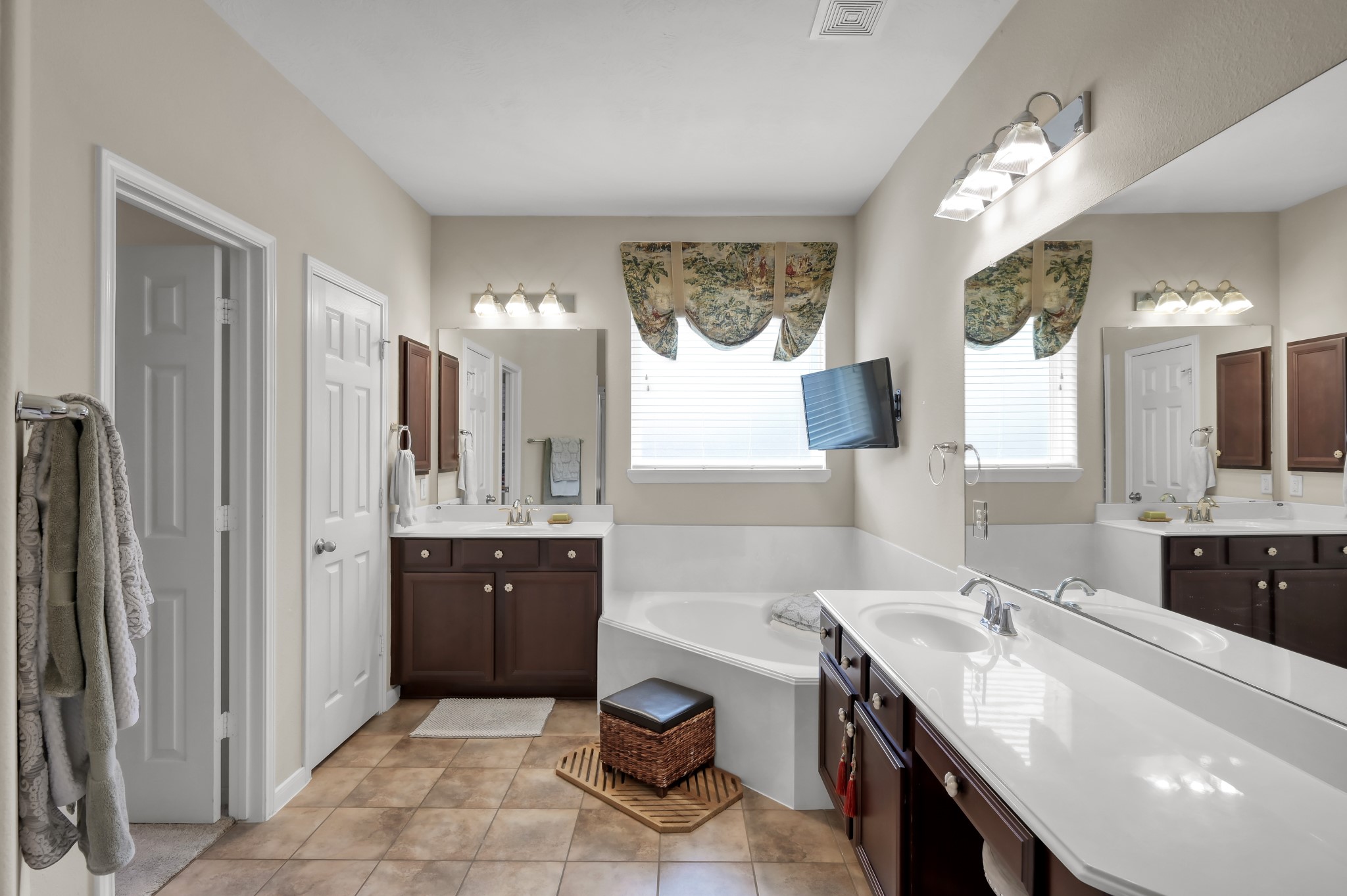 Relax and unwind in the spacious primary bathroom featuring dual sinks, soaking tub, separate shower, and an open layout designed for convenience and comfort.