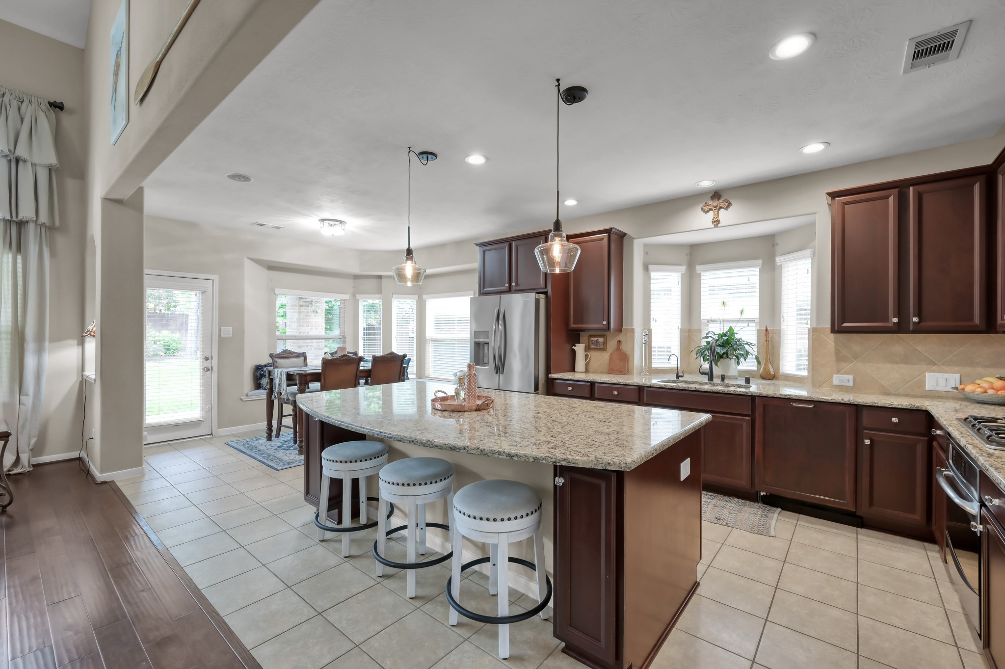Bright breakfast nook with charming window seating and backyard views creates a cozy dining space filled with natural light. Easy access to the patio makes indoor/outdoor entertaining simple.