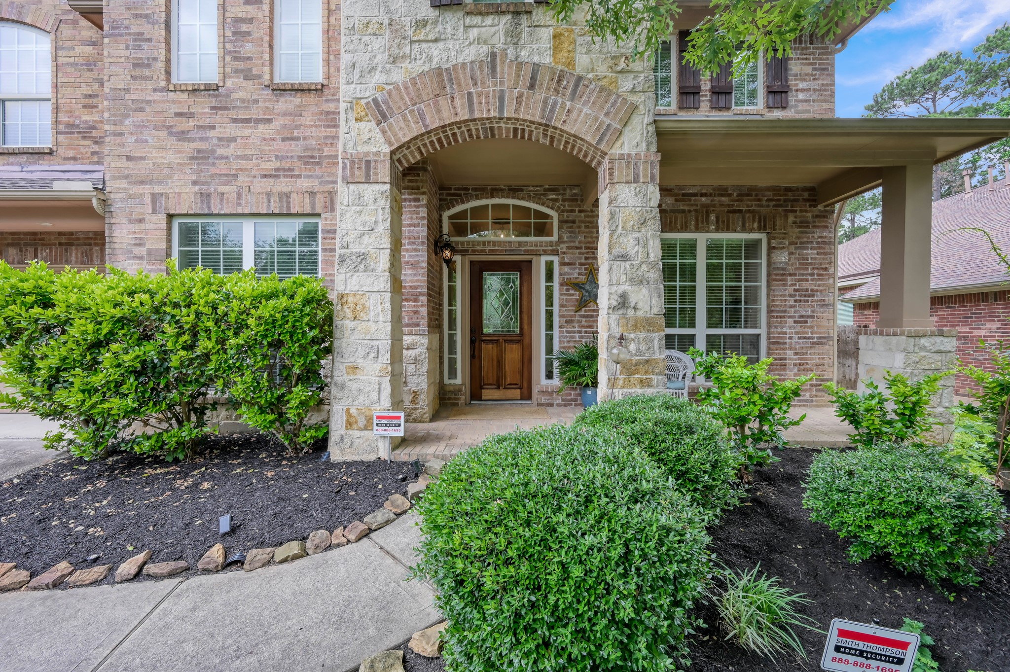 The covered front porch and impressive stone archway create the perfect place to greet guests or enjoy a peaceful morning coffee. Beautiful landscaping and custom front door details add to the homes charm. The covered front porch and impressive stone archway create the perfect place to greet guests or enjoy a peaceful morning coffee. Beautiful landscaping and custom front door details add to the homes charm.