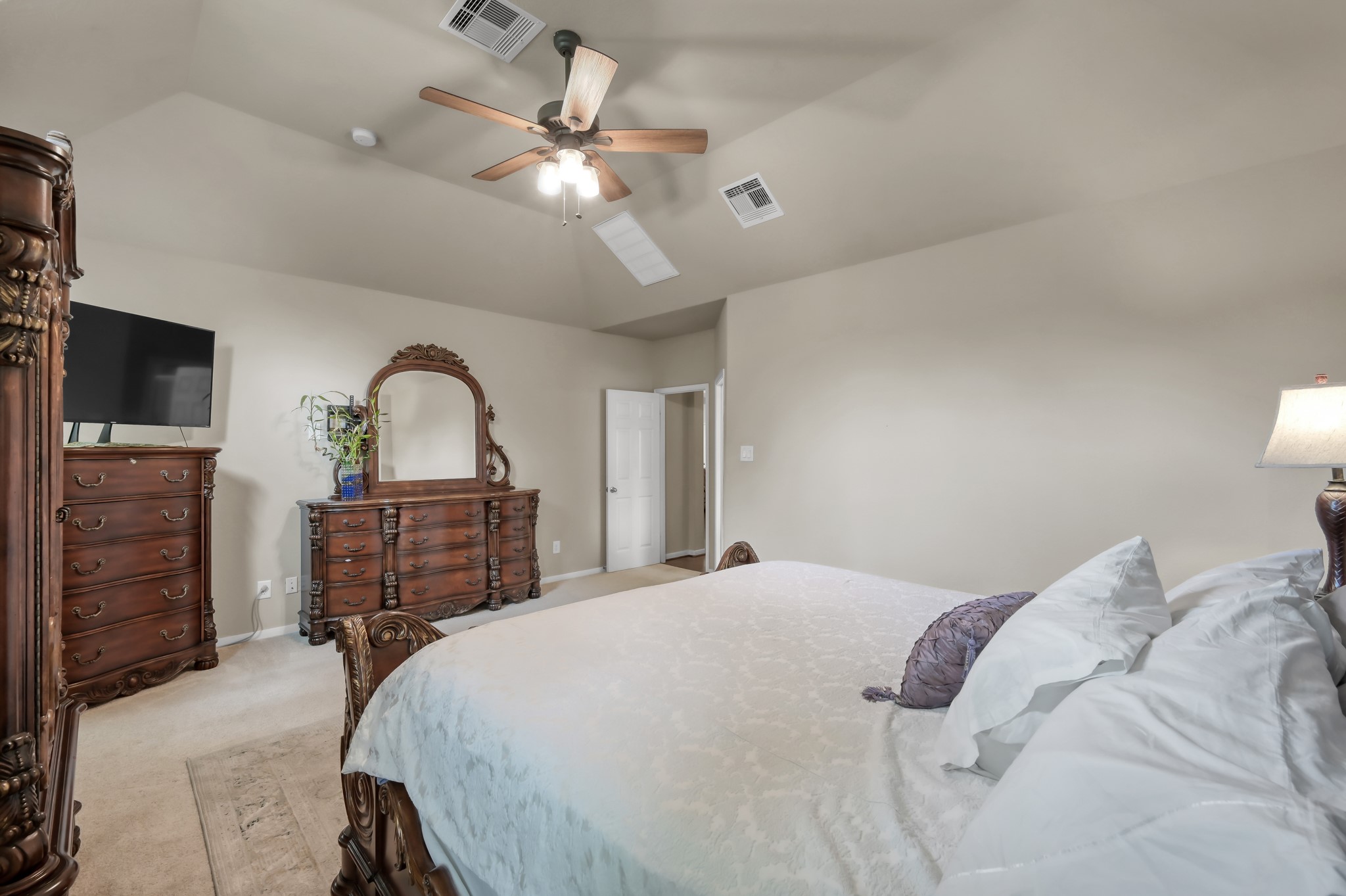 Spacious primary suite with high ceilings, neutral tones, and plenty of room for oversized furniture. A peaceful retreat with soft natural light and a comfortable, relaxing feel.