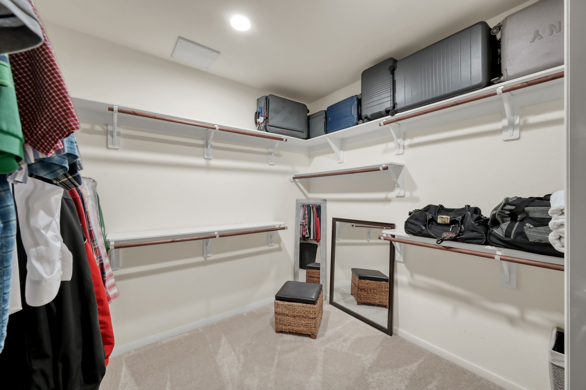 Large walk-in closet with abundant hanging space, upper storage shelves, and room to keep everything neatly organized.