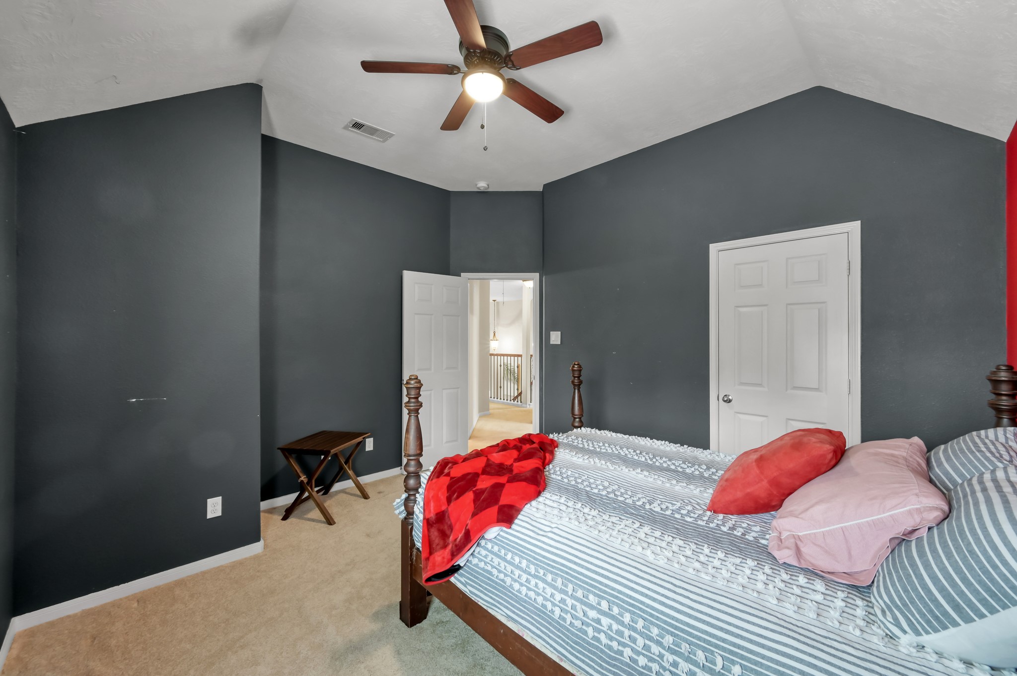 Another look at this stylish bedroom showcasing dramatic accent walls, vaulted ceilings, and a comfortable, inviting atmosphere.