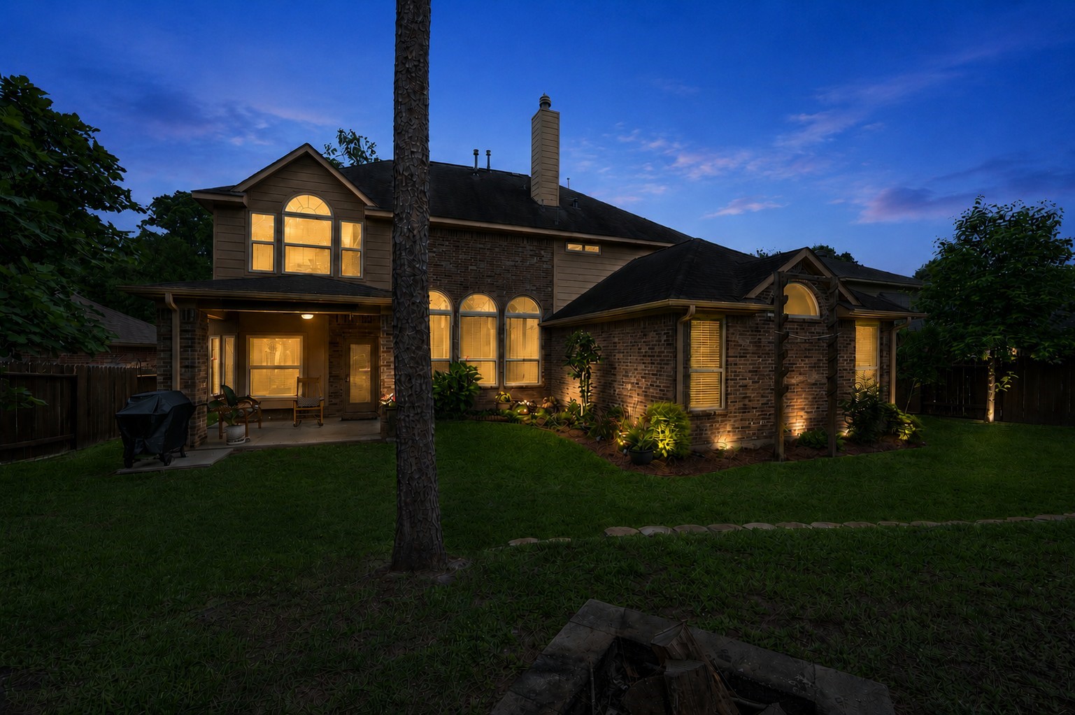 Beautifully maintained backyard with mature landscaping, wide open green space, and peaceful wooded surroundings that create a private outdoor retreat.