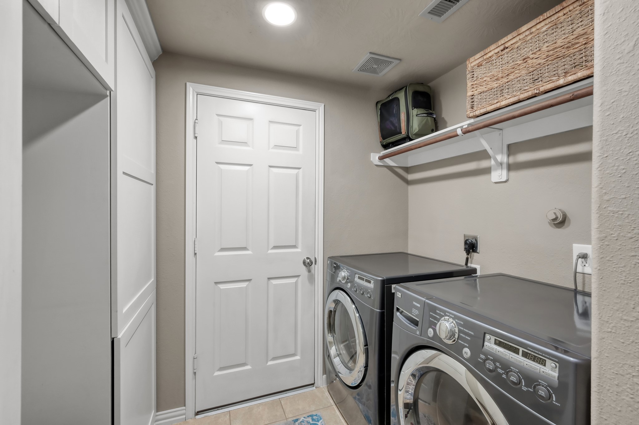 Functional laundry room with built-in storage, shelving, and space to keep everything organized and convenient.