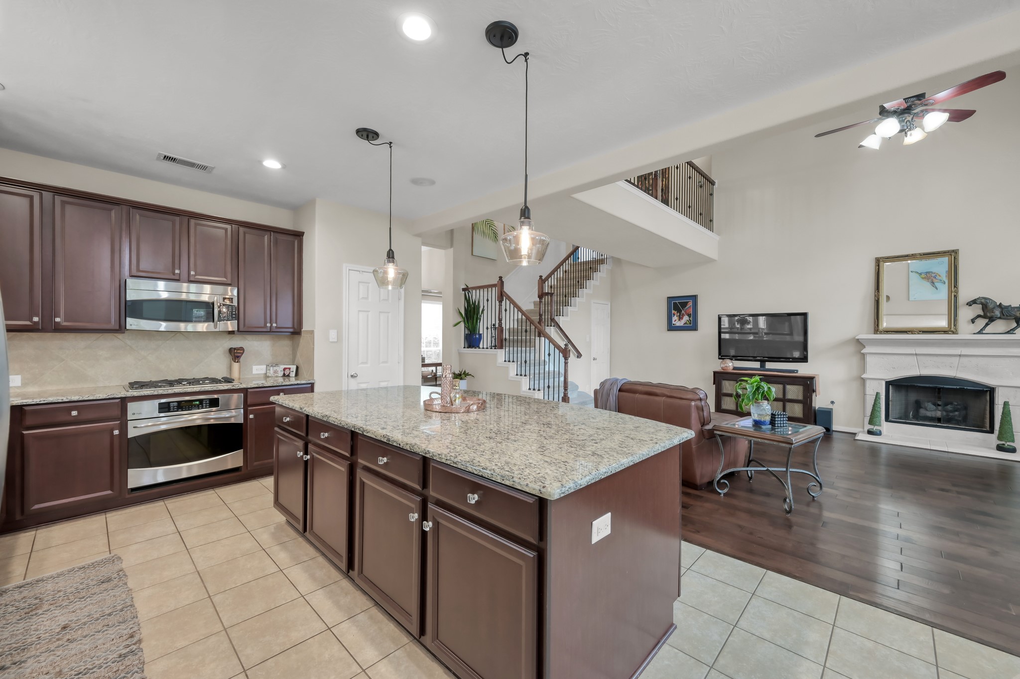 This spacious kitchen overlooks the family room, making it perfect for entertaining or staying connected while cooking. The oversized island, pendant lighting, and open layout create a bright and welcoming gathering space.