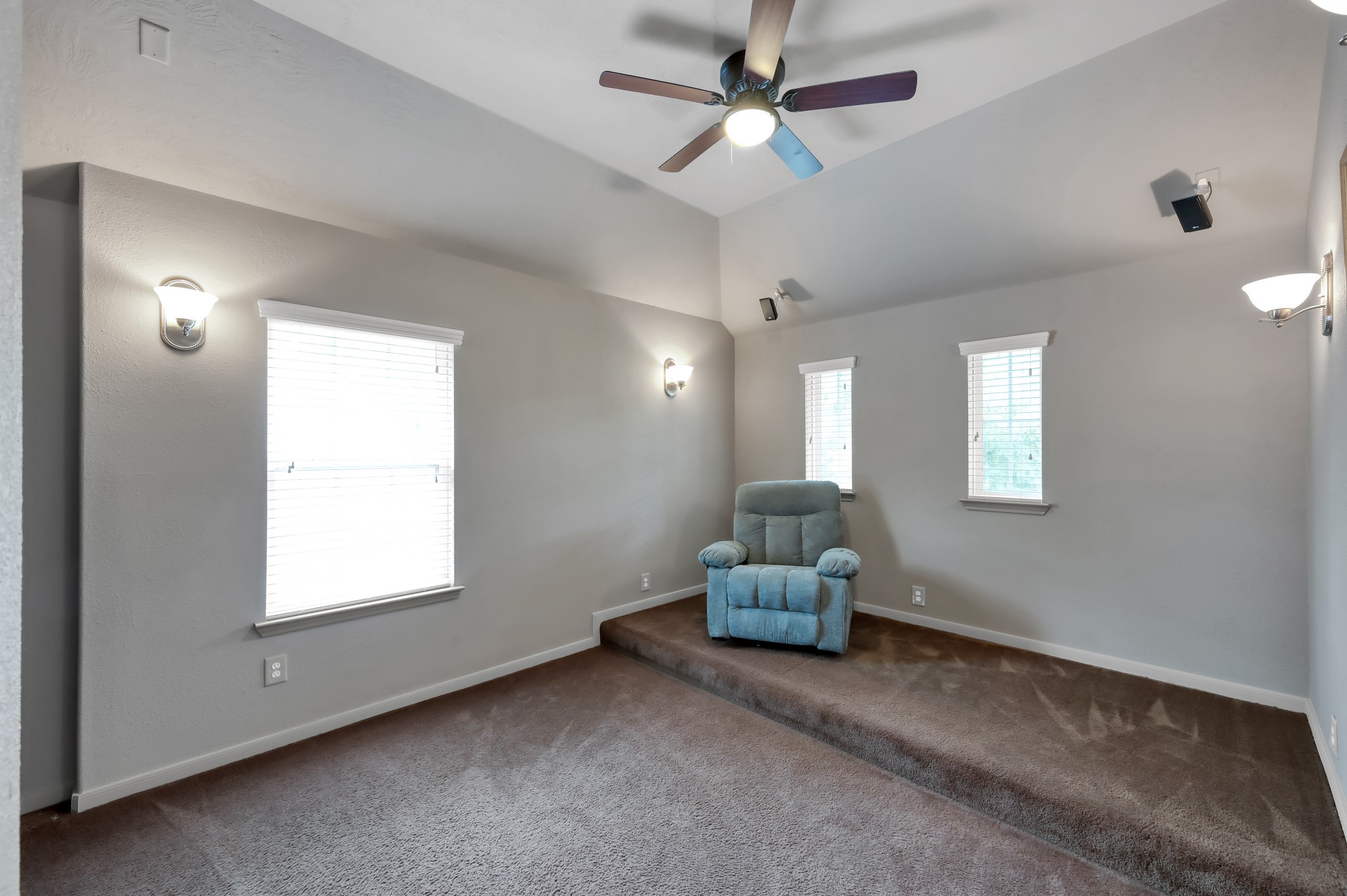 Private media room with raised viewing area and surround sound setup, creating the perfect space for a home cinema experience.