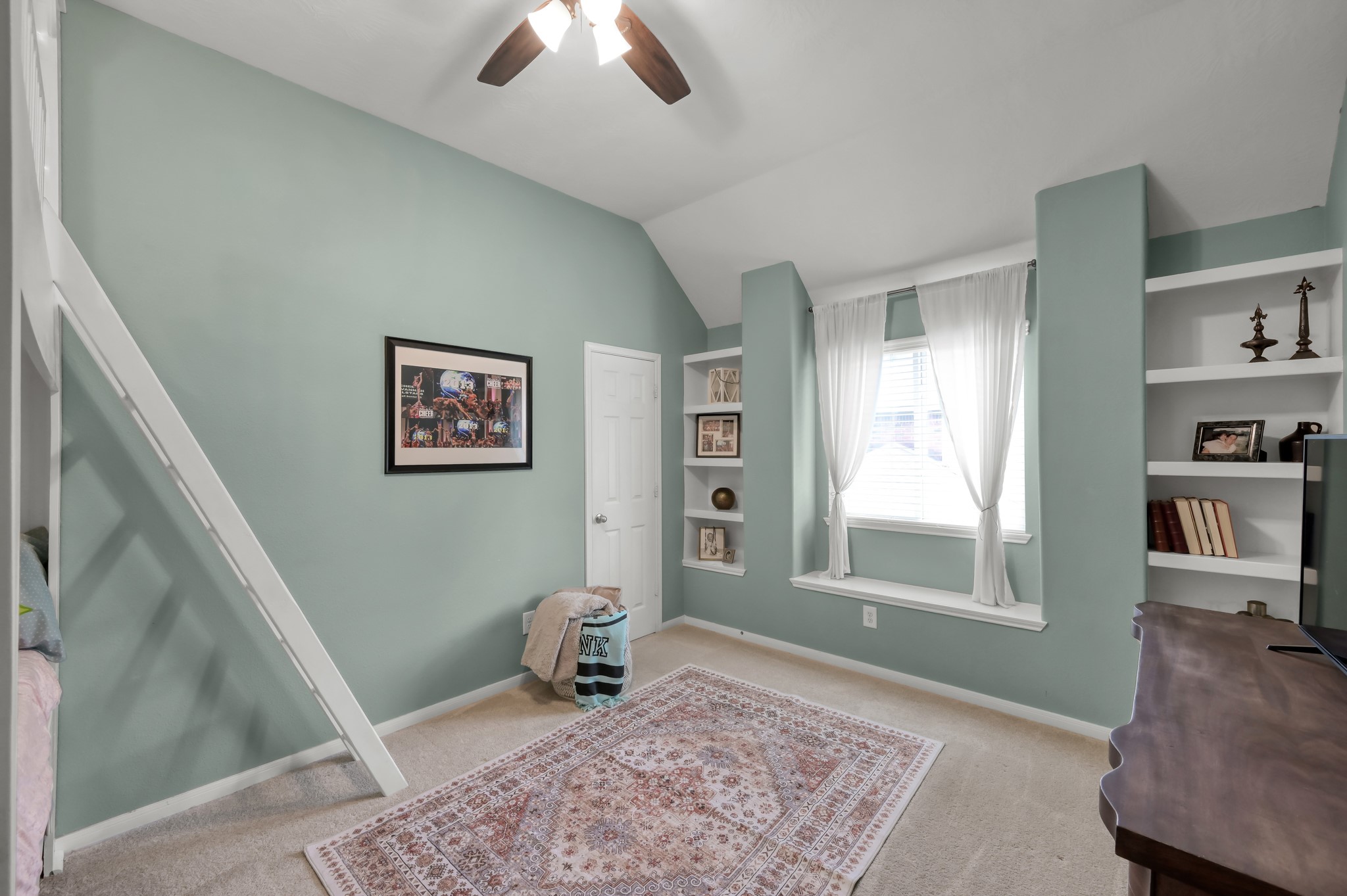 Spacious bedroom with soaring ceilings, built-in shelving, window seating, and unique architectural details that give the space extra character.
