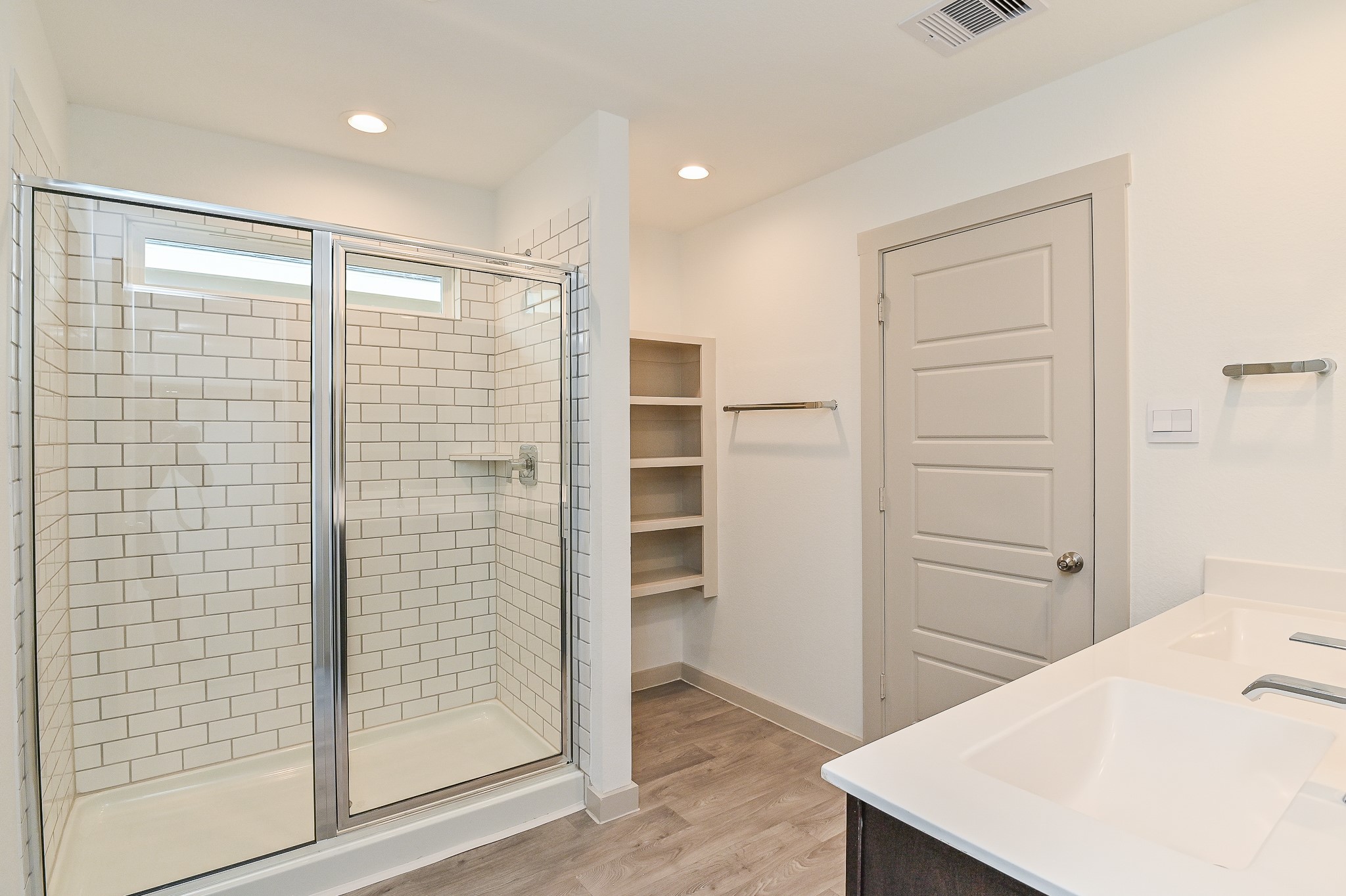 Walk-in shower with subway tiling and built in shelving is great for storage.