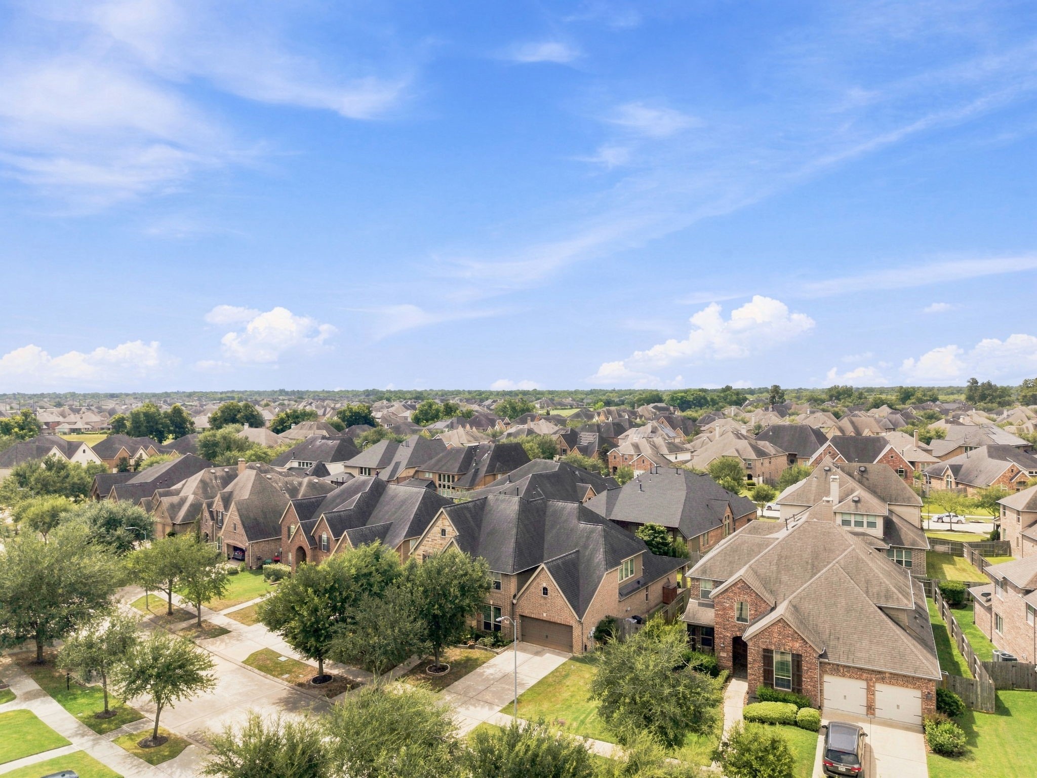 Aerial view of the home's rooftop within the Riverstone community, surrounded by tree-lined streets and neighborhood. Aerial view of the home's rooftop within the Riverstone community, surrounded by tree-lined streets and neighborhood.