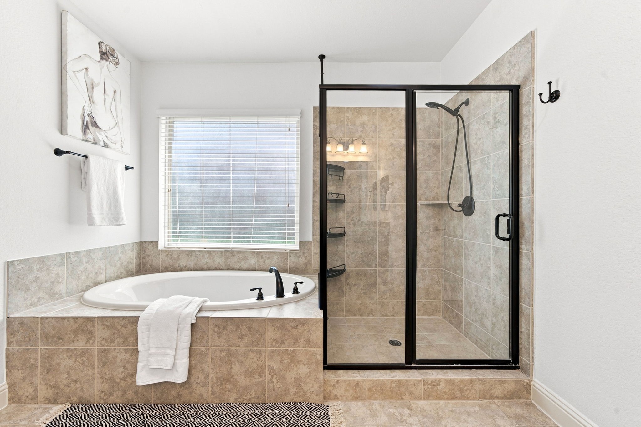 Relaxing garden soaking tub with a separate oversized glass-enclosed walk-in shower.