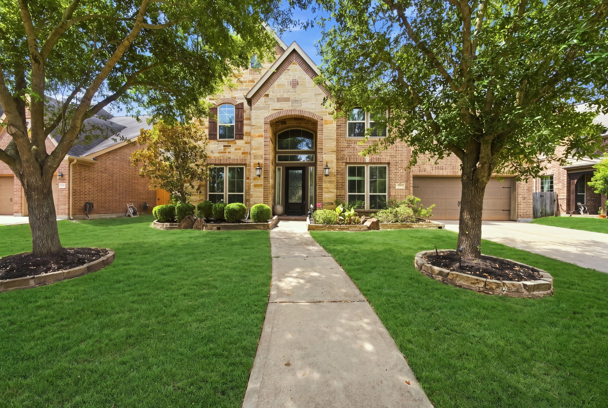 Elegant brick and stone home with a covered entry, and arched front door. Elegant brick and stone home with a covered entry, and arched front door.
