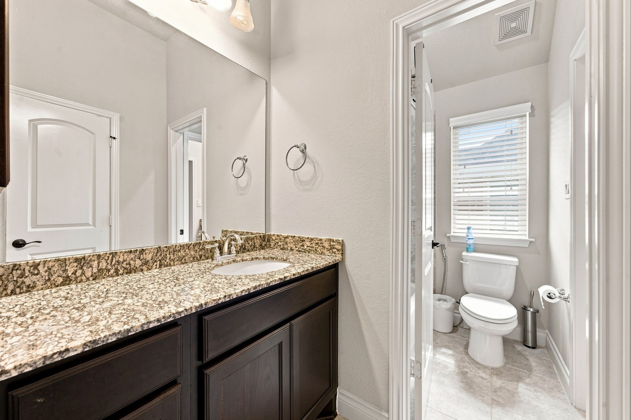 A thoughtfully designed Jack-and-Jill bath adds flexibility to the home, offering shared vanity space and a separate private bath area for a smoother morning routine