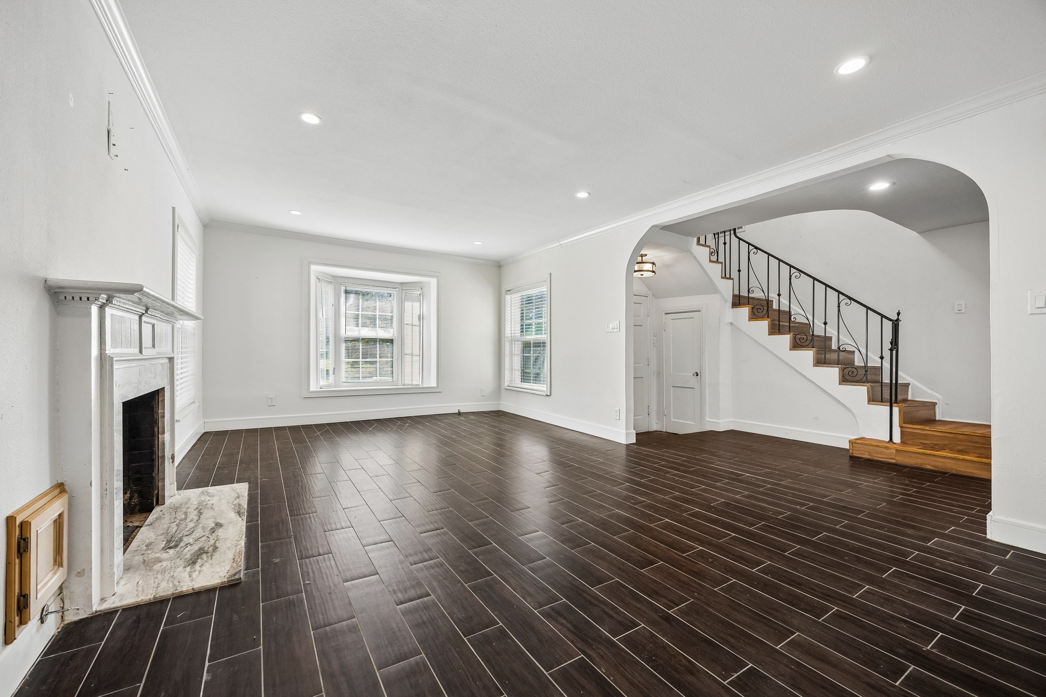 Formal living room with fireplace and arched opening to the staircase.