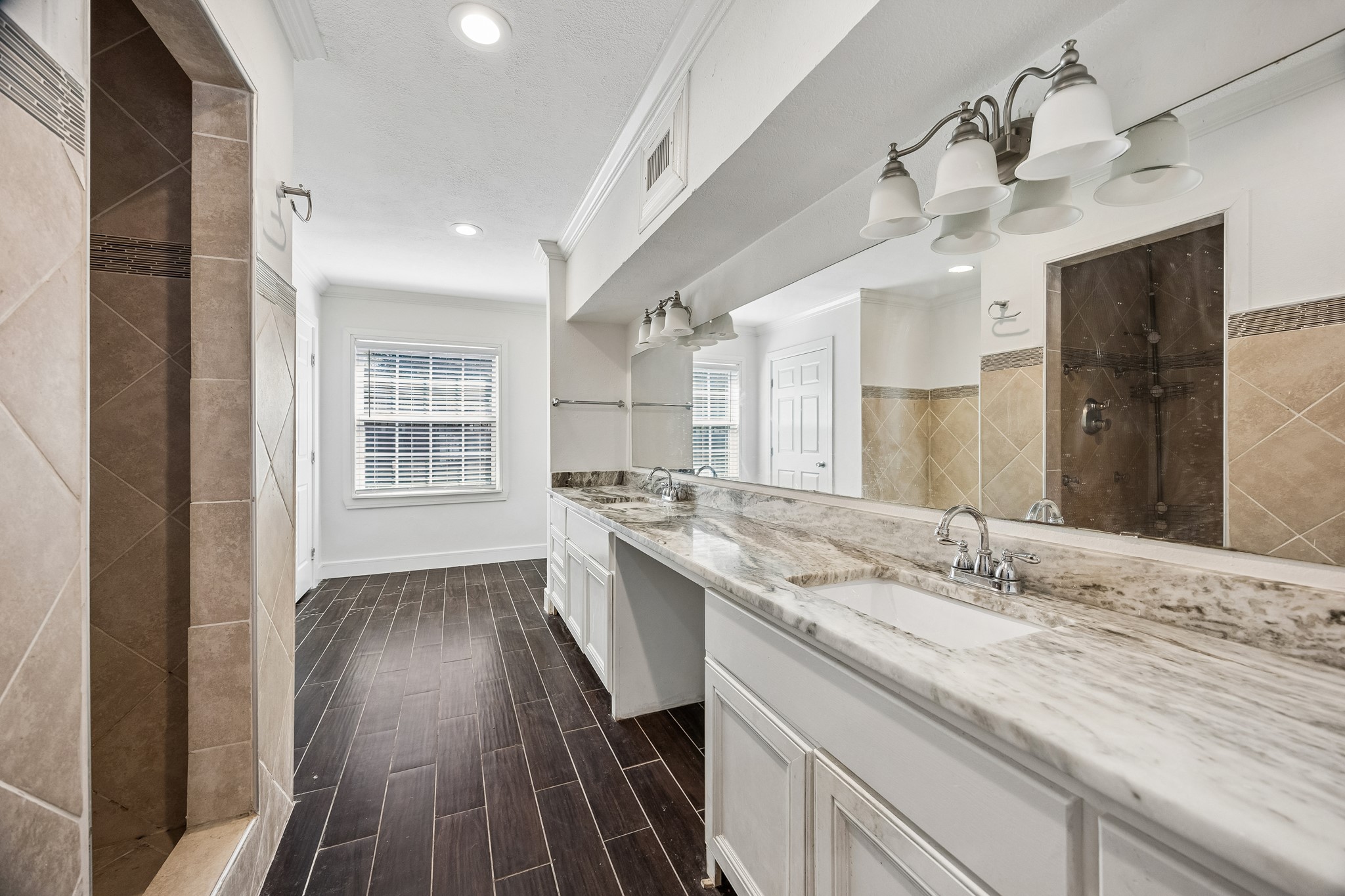 Primary bath offers double sinks with knee space and a walk-in shower.