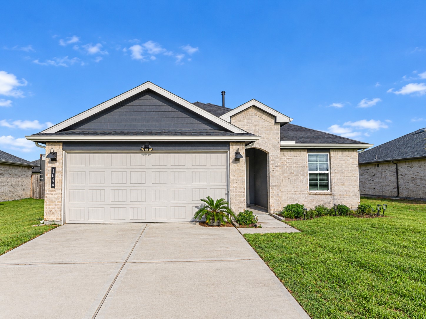 Beautiful front exterior showcasing the home's attractive curb appeal and a scenic view of the community pond and walking trails, creating a peaceful and inviting setting right outside your door.