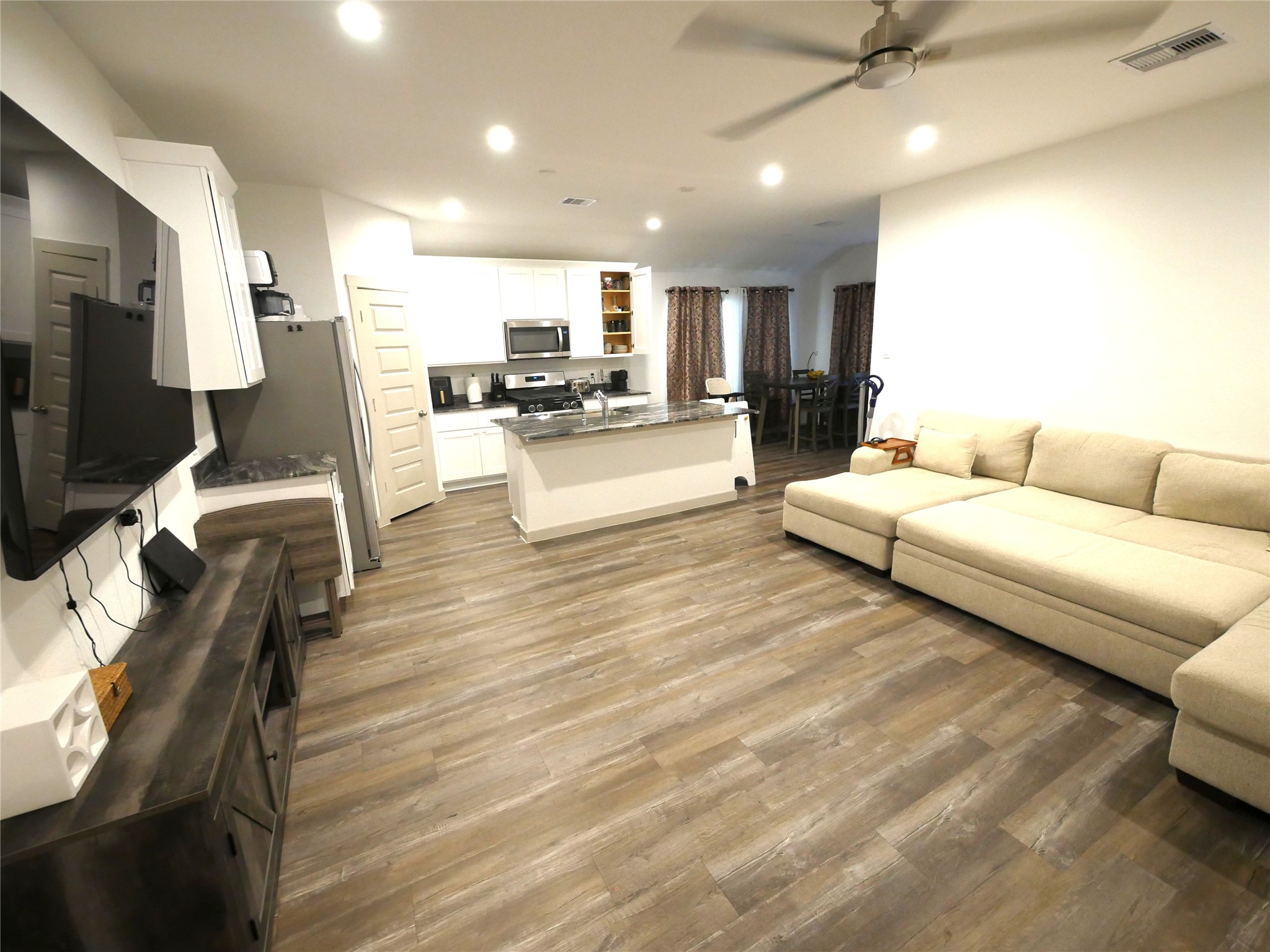 Open-concept living area featuring abundant natural light, modern finishes, and a spacious layout that flows seamlessly into the kitchen and dining areas. Open-concept living area featuring abundant natural light, modern finishes, and a spacious layout that flows seamlessly into the kitchen and dining areas.