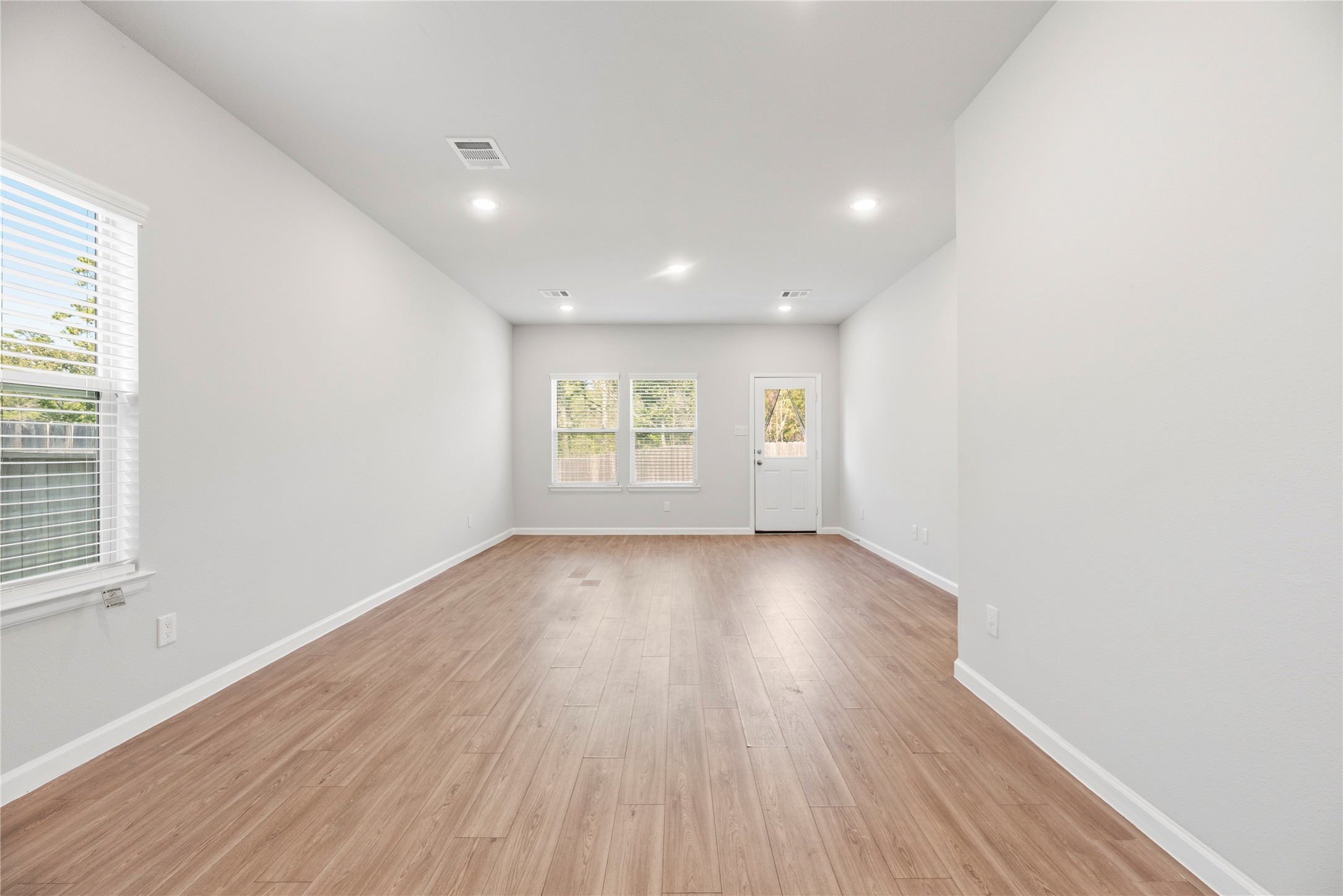 The elongated living area offers options for arranging your seating and dining furniture, with the back door providing an easy connection to the patio.