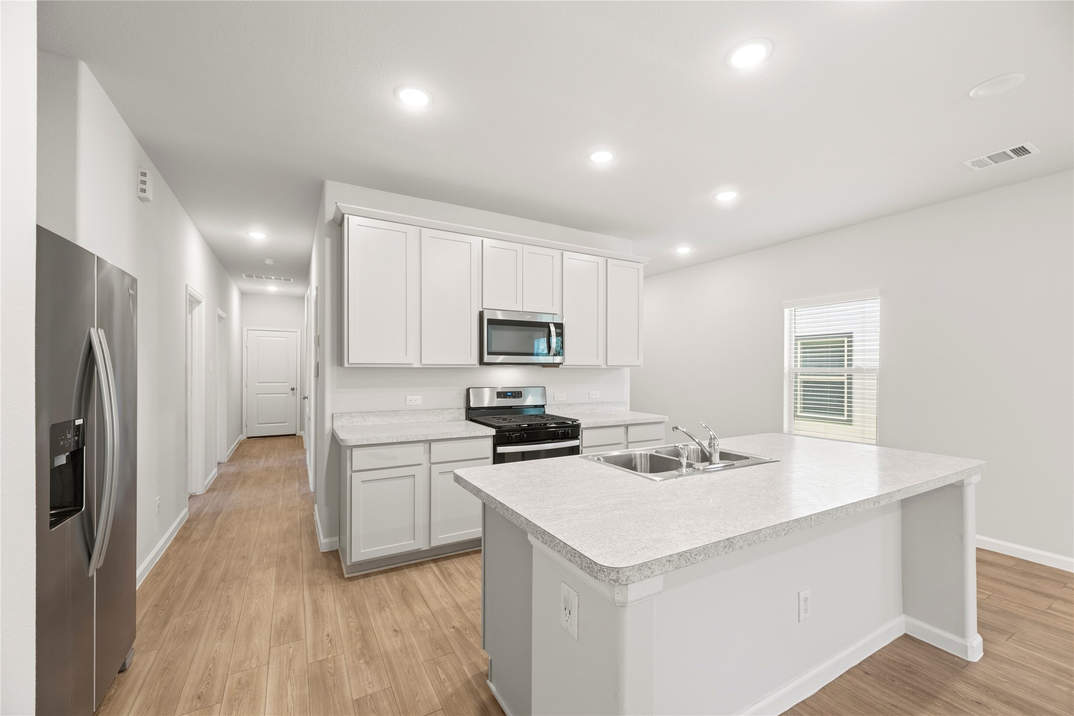 The island anchors the kitchen with a sink and dishwasher close at hand, bringing meal preparation and cleanup together in one convenient workspace.