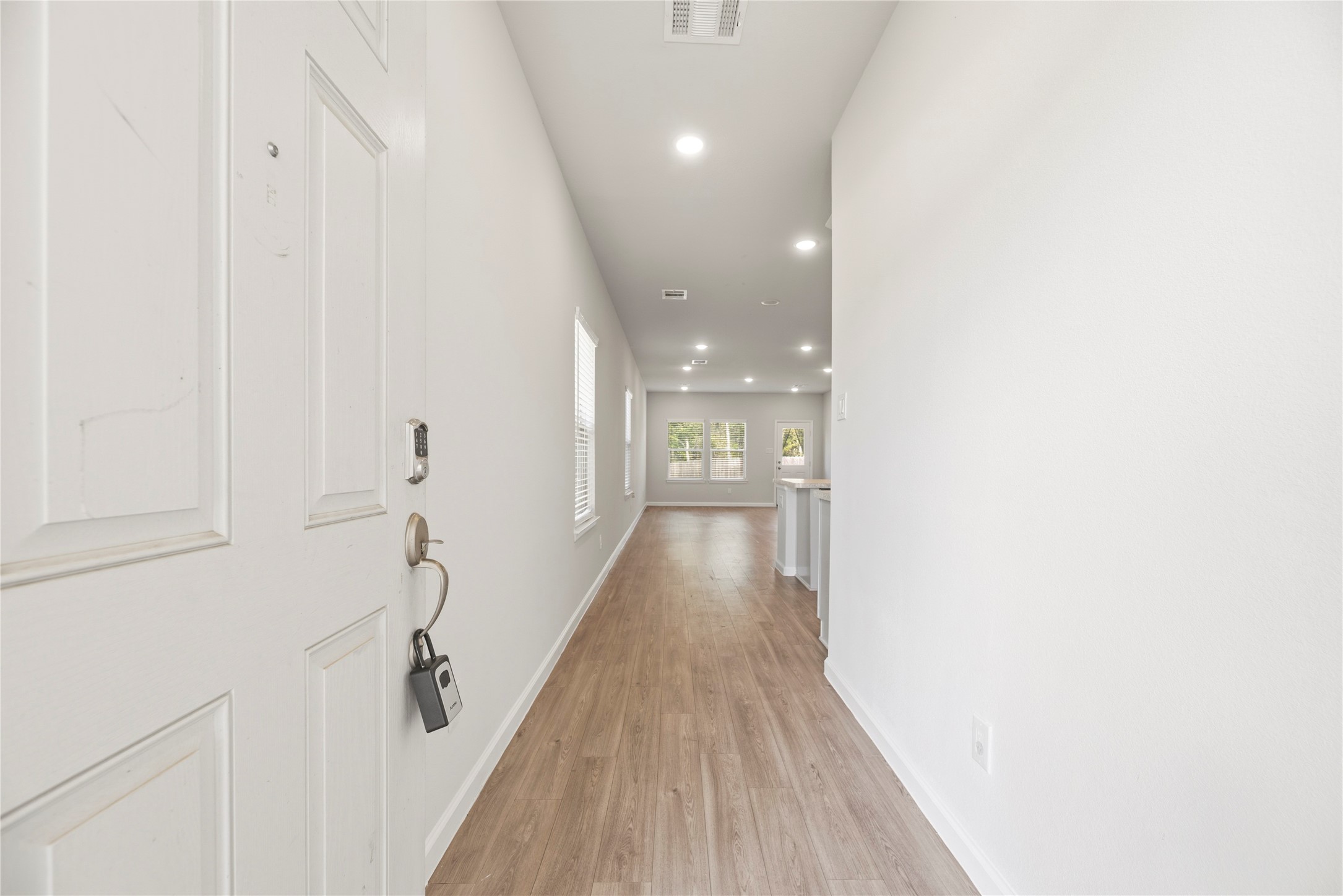 Step inside to a long entry hall that opens toward the main gathering space. Wood-look flooring creates a continuous connection from the front door to the living area.