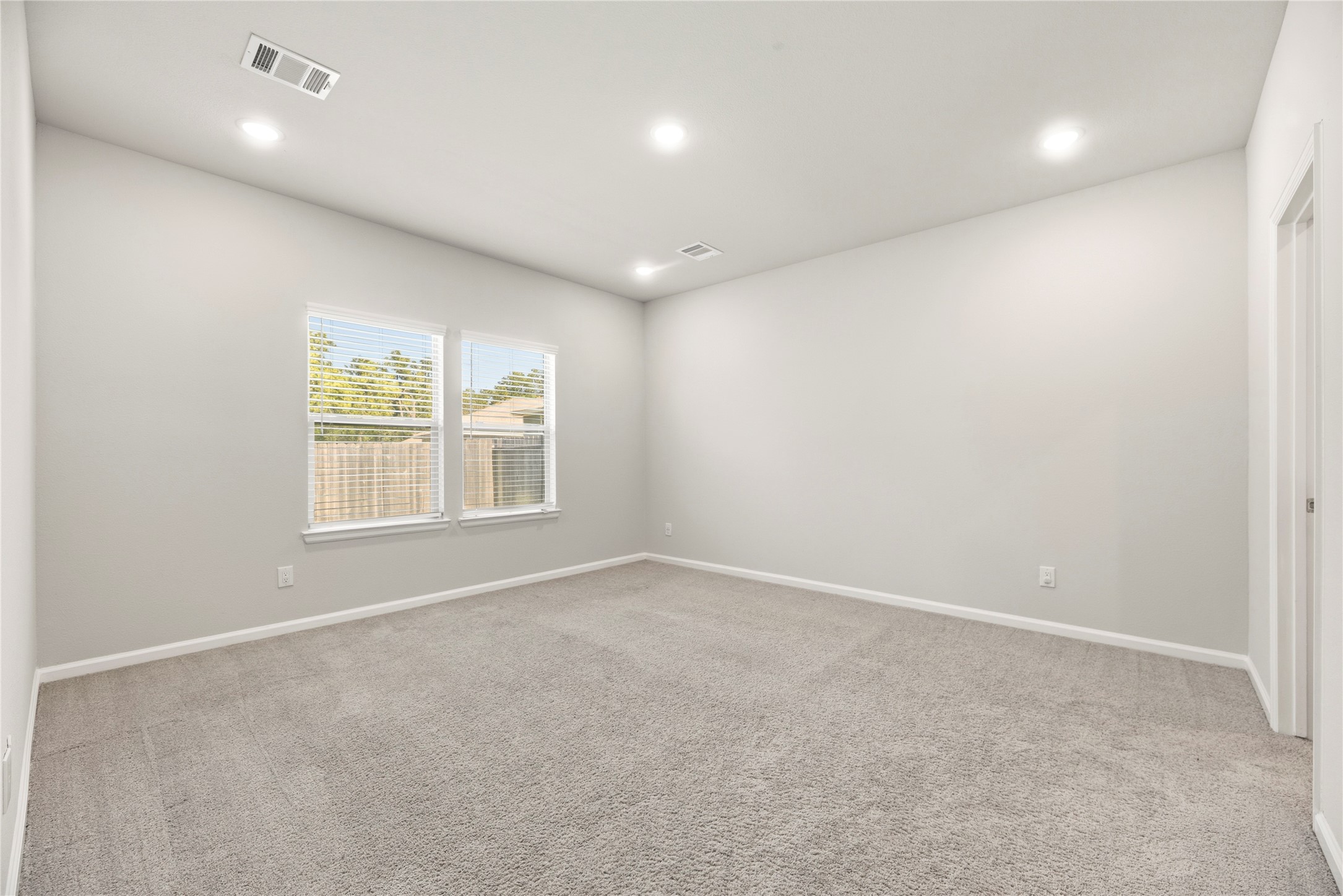 A soft neutral palette, carpet underfoot and natural light create a restful bedroom setting, ready for your own furniture and finishing touches.