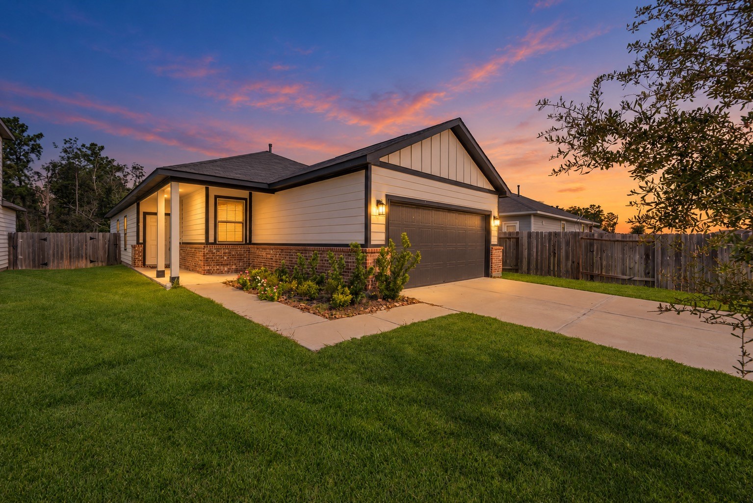 The covered entry and contrasting exterior finishes take on a warm evening glow in this digitally enhanced twilight view. Daytime exterior photos are also included.