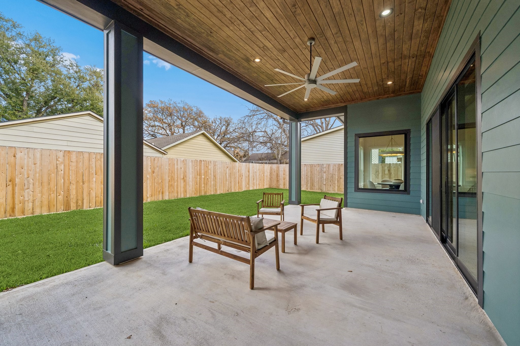 This huge back covered patio has a wood paneled ceiling and fan. It's plumbed for an outdoor kitchen. Plenty of room for a pool.
