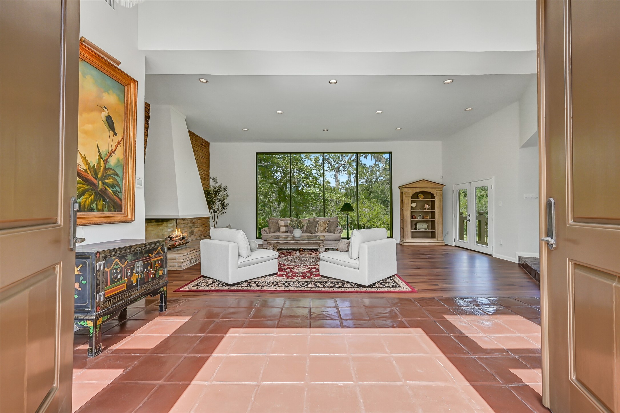 Measuring approximately 29' x 27', the expansive sunken living room features 12' ceilings, recessed lighting & a dramatic stone fireplace with sculptural stucco hood and extended stone hearth. Oversized windows frame beautiful views of the surrounding acreage, filling the room with natural light.