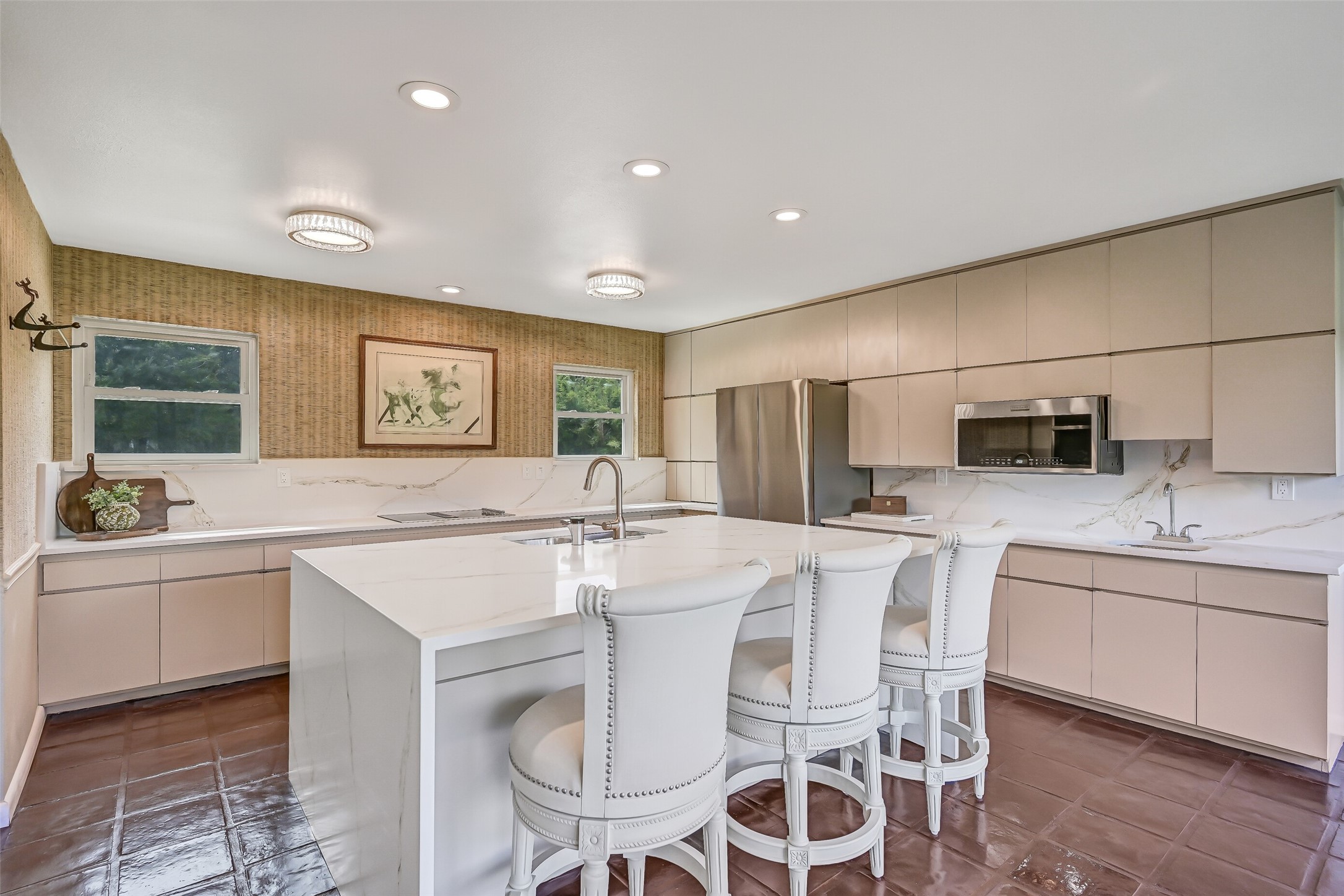 Extensive cabinetry lines the kitchen walls, offering an abundance of storage alongside stainless appliances, an electric cooktop, built-in microwave & double ovens. A convenient secondary sink provides an additional prep area, while the oversized island anchors this spacious 2024 renovation.