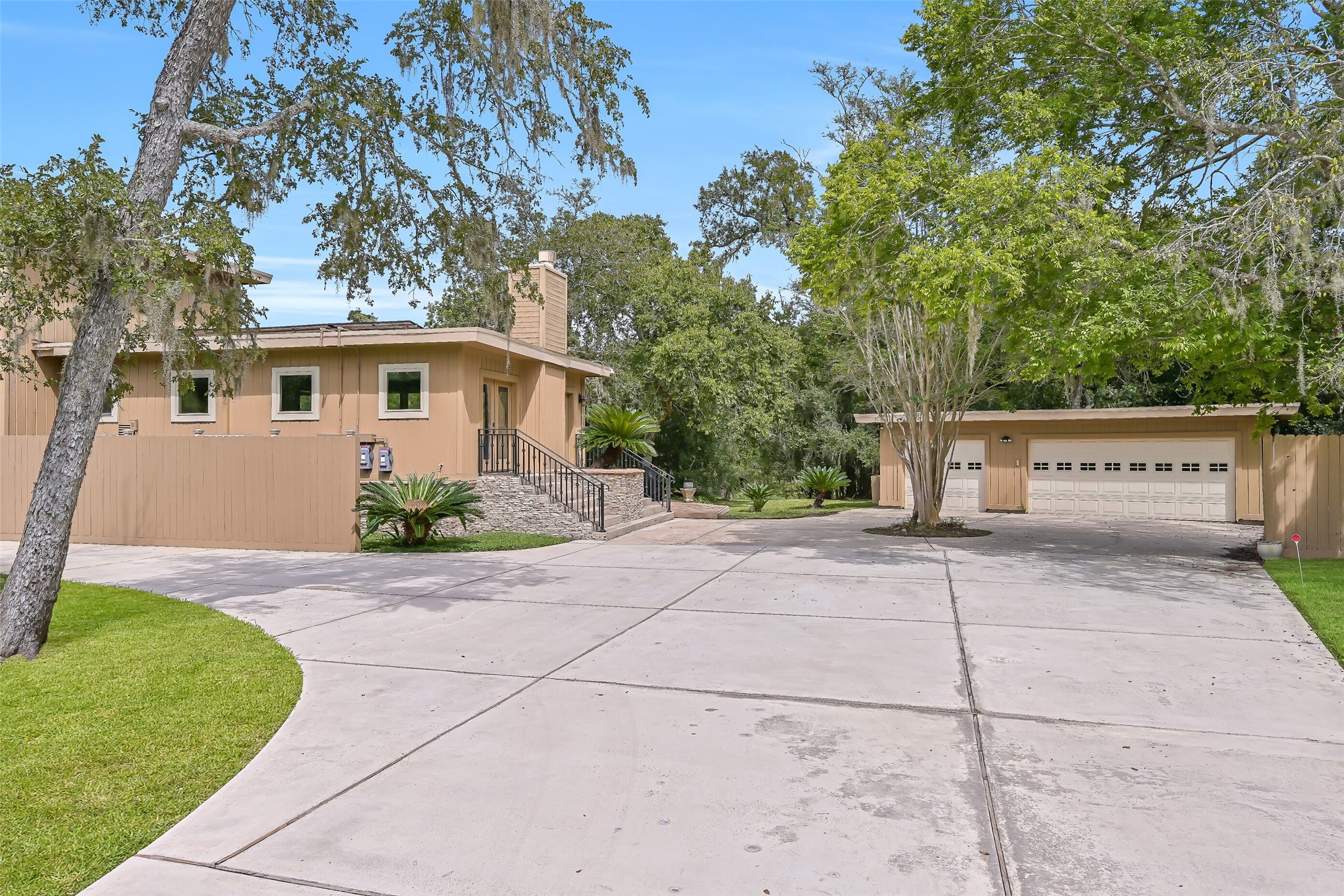 The expansive concrete driveway provides abundant additional parking as it leads to the detached 2-car garage, complete with a separate single-width garage door. Mature trees, established landscaping & stone exterior accents complement the home's distinctive architecture and secluded setting.