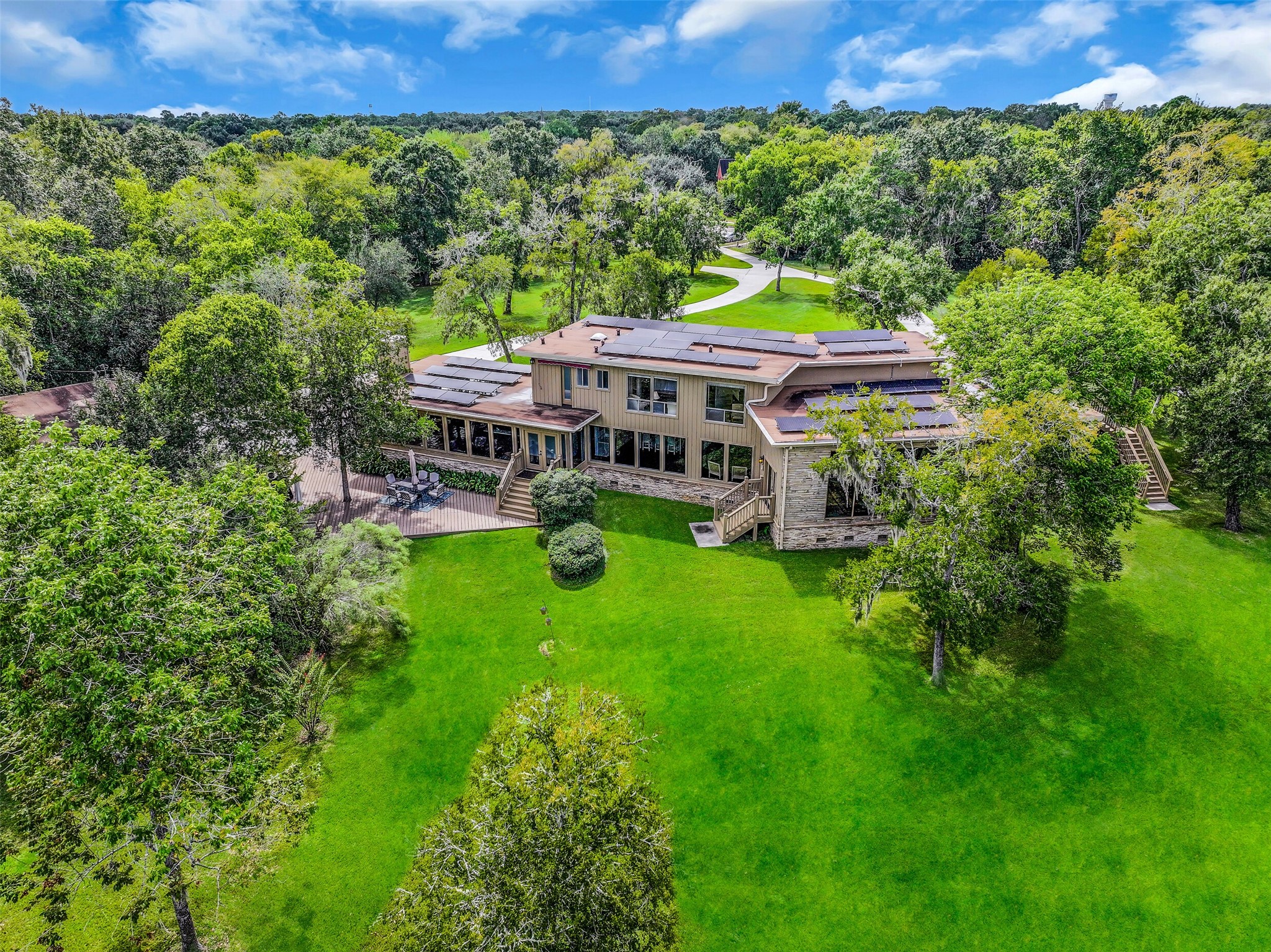 Tucked away at the end of a private cul-de-sac, this architecturally distinctive home occupies 4.749 acres near the heart of Friendswood. A sweeping driveway leads through the secluded grounds to the home, surrounded by mature trees, expansive lawns & the natural setting of Cowart Creek.