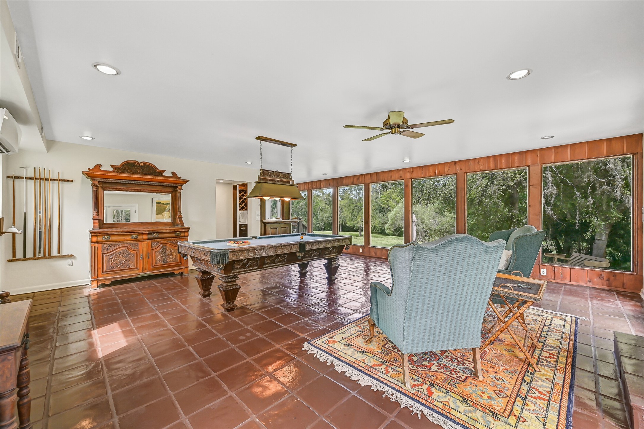 This impressively sized gameroom provides abundant space for a full-sized pool table & separate sitting area. Painted tile flooring, recessed lighting, a ceiling fan & a wall of oversized picture windows overlooking the acreage complete this spacious addition.