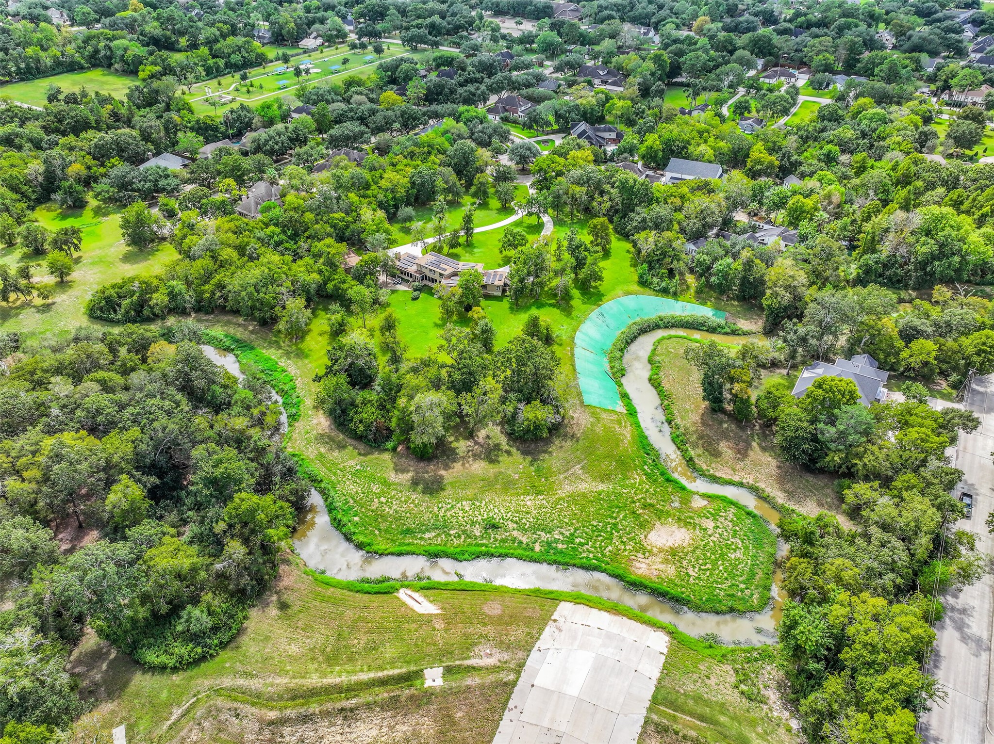 A closer aerial reveals the home's distinctive contemporary architecture, extensive circular driveway & detached 2-car garage. The residence sits well removed from the street, surrounded by mature landscaping with generous open space extending across the property's 4.749 acres.