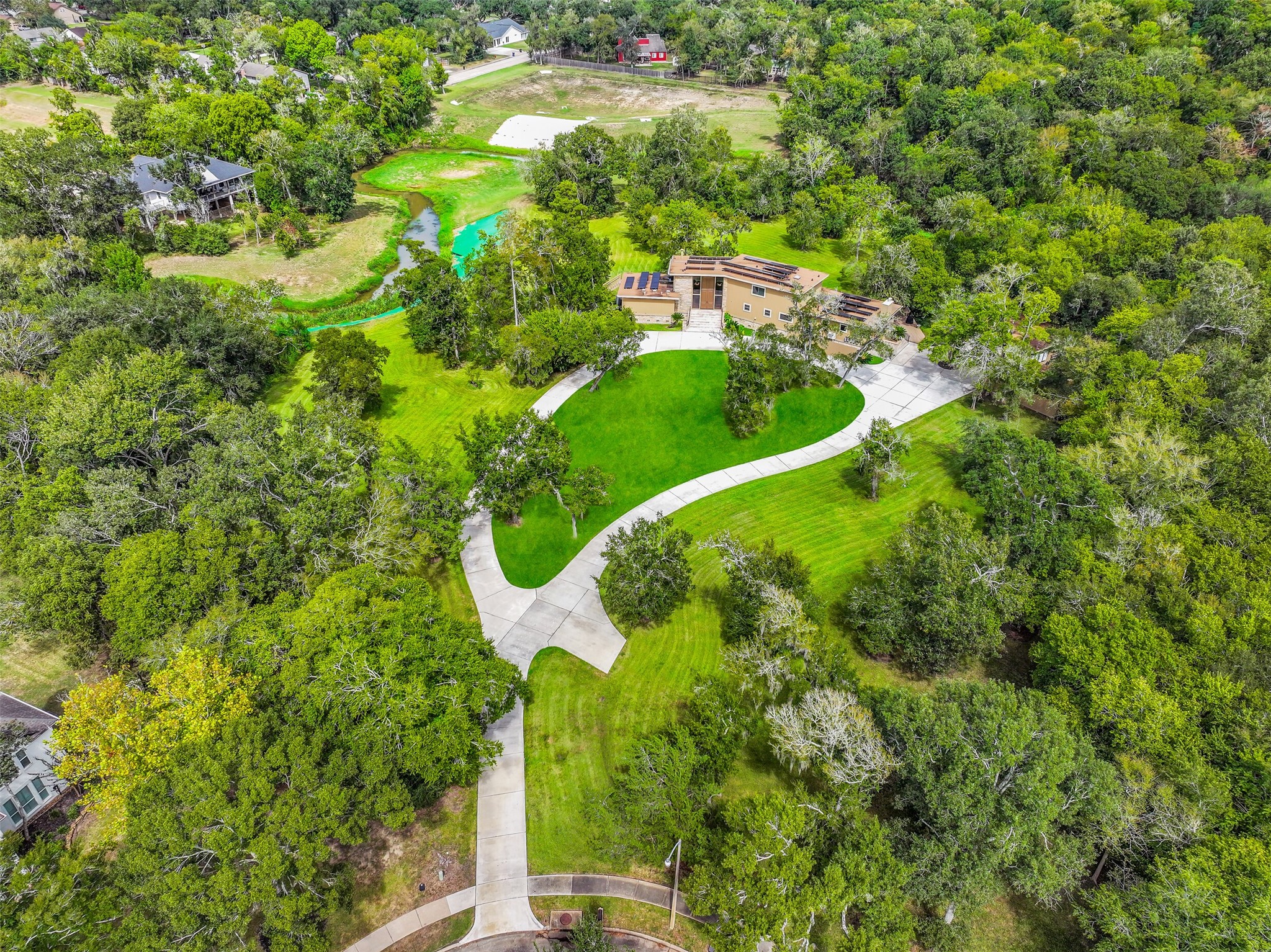 The home's sprawling footprint is surrounded by established trees & expansive green space, with a long driveway connecting the residence to the cul-de-sac. Notice the detached garage, extensive parking areas & multiple outdoor spaces that take advantage of the acreage.