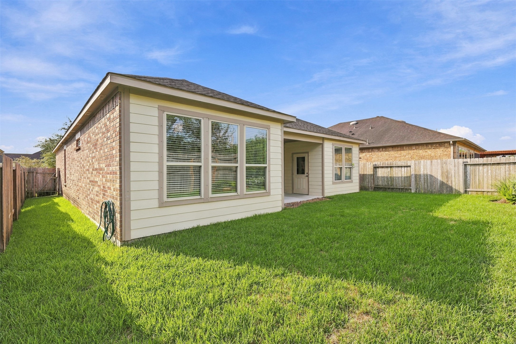 Covered patio and landscaped backyard.