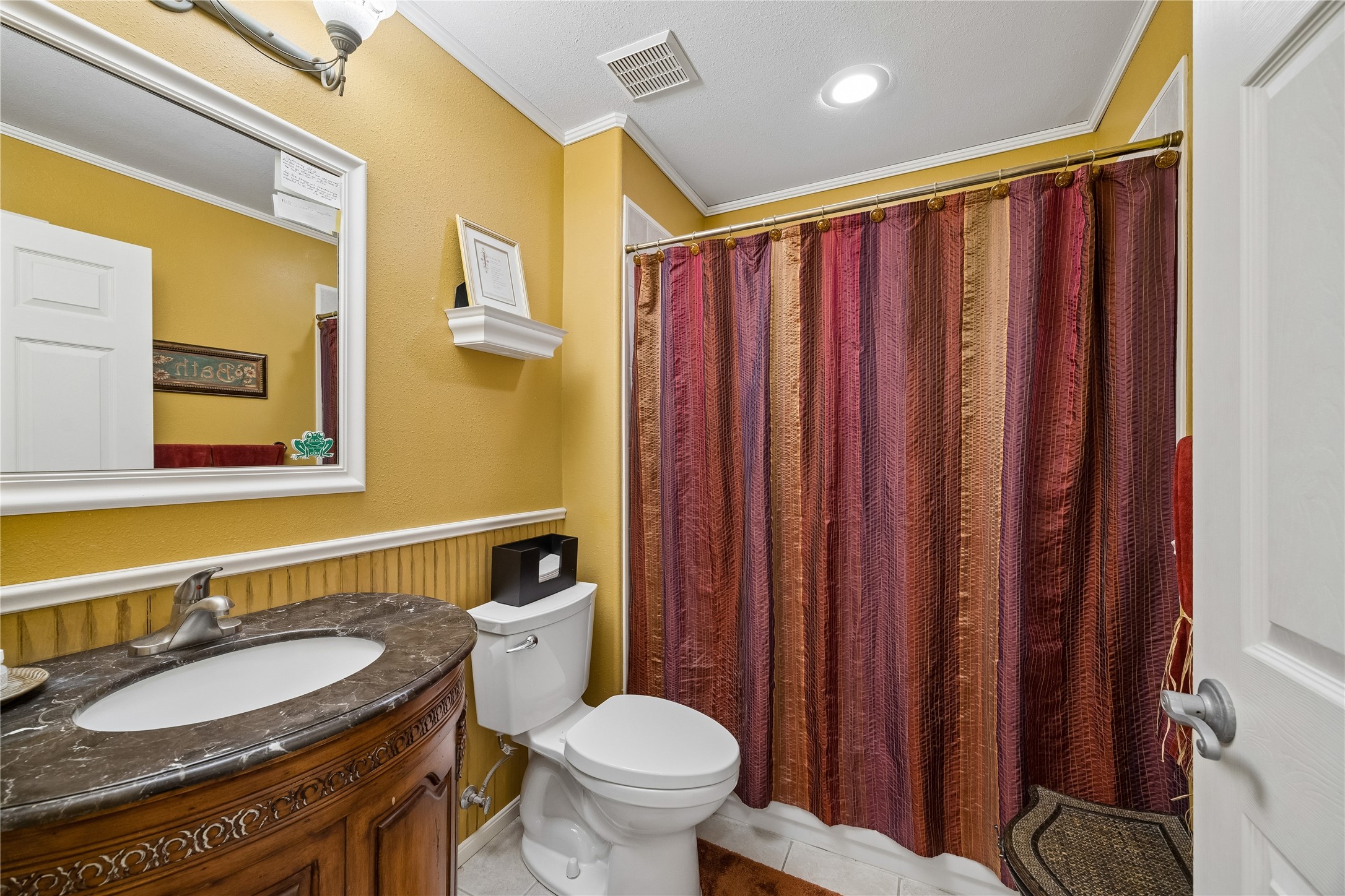 Full bath featuring an elegant rounded wooden vanity and a traditional shower-tub combo