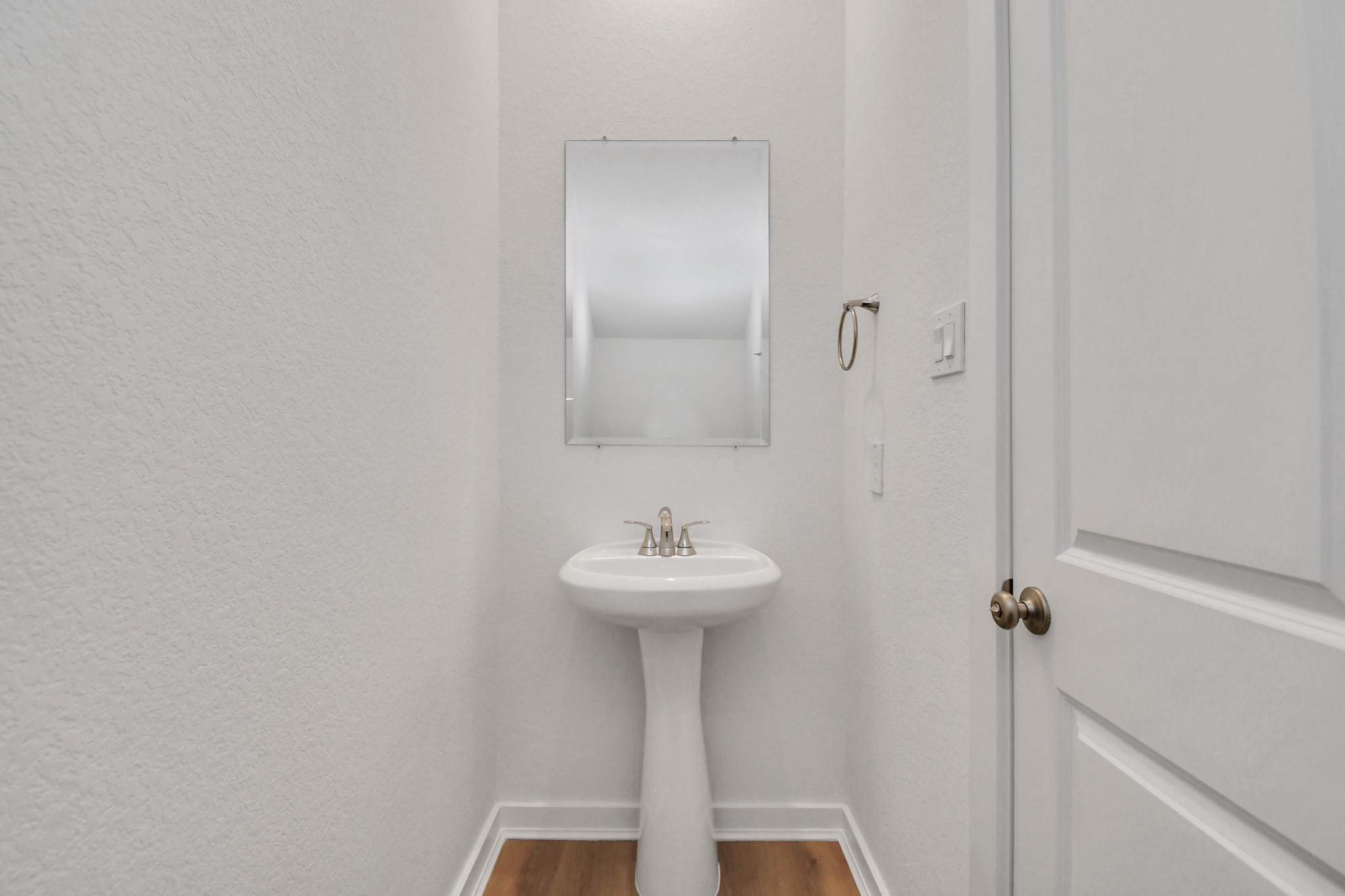 This crisp, white powder room offers a clean and simple design, creating a fresh and inviting space.