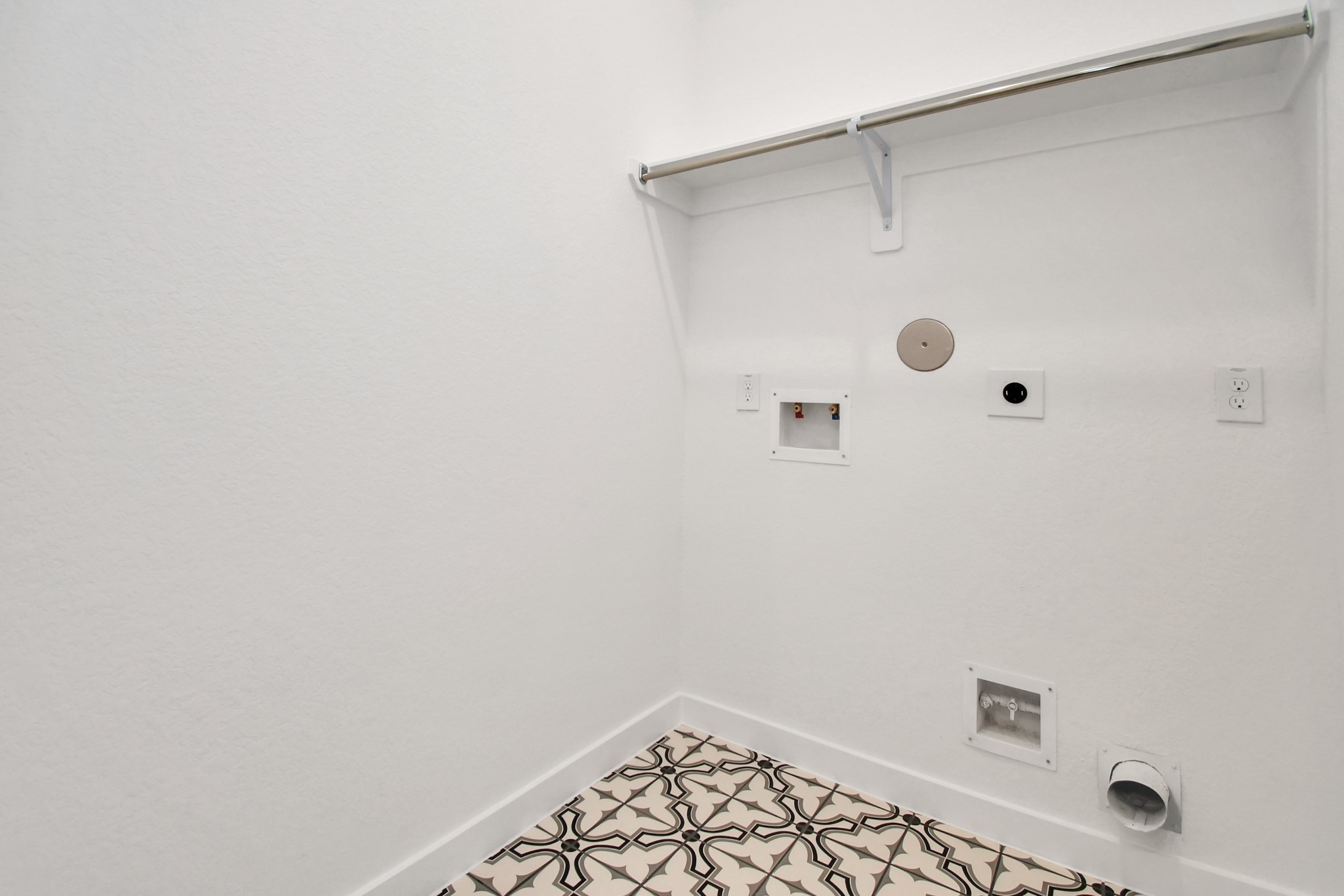 The laundry room features stylish tile flooring, adding a touch of charm to the functional space.