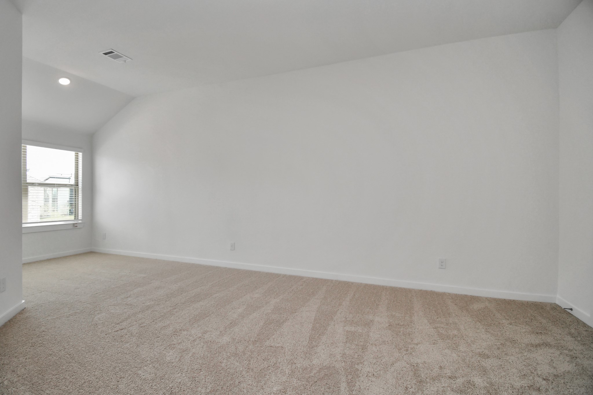 The spacious primary bedroom boasts plush carpet, providing a comfortable and inviting retreat.