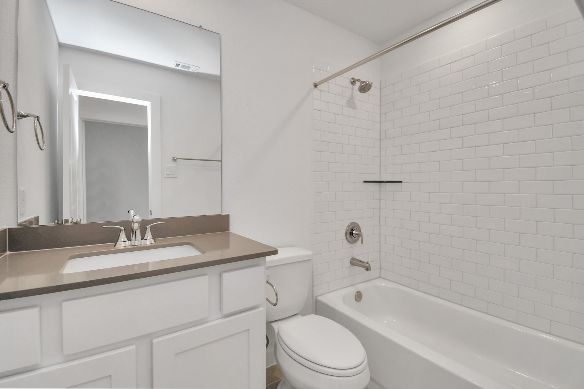The hall bathroom features a clean white design and includes a convenient tub-shower combo for versatile bathing options.