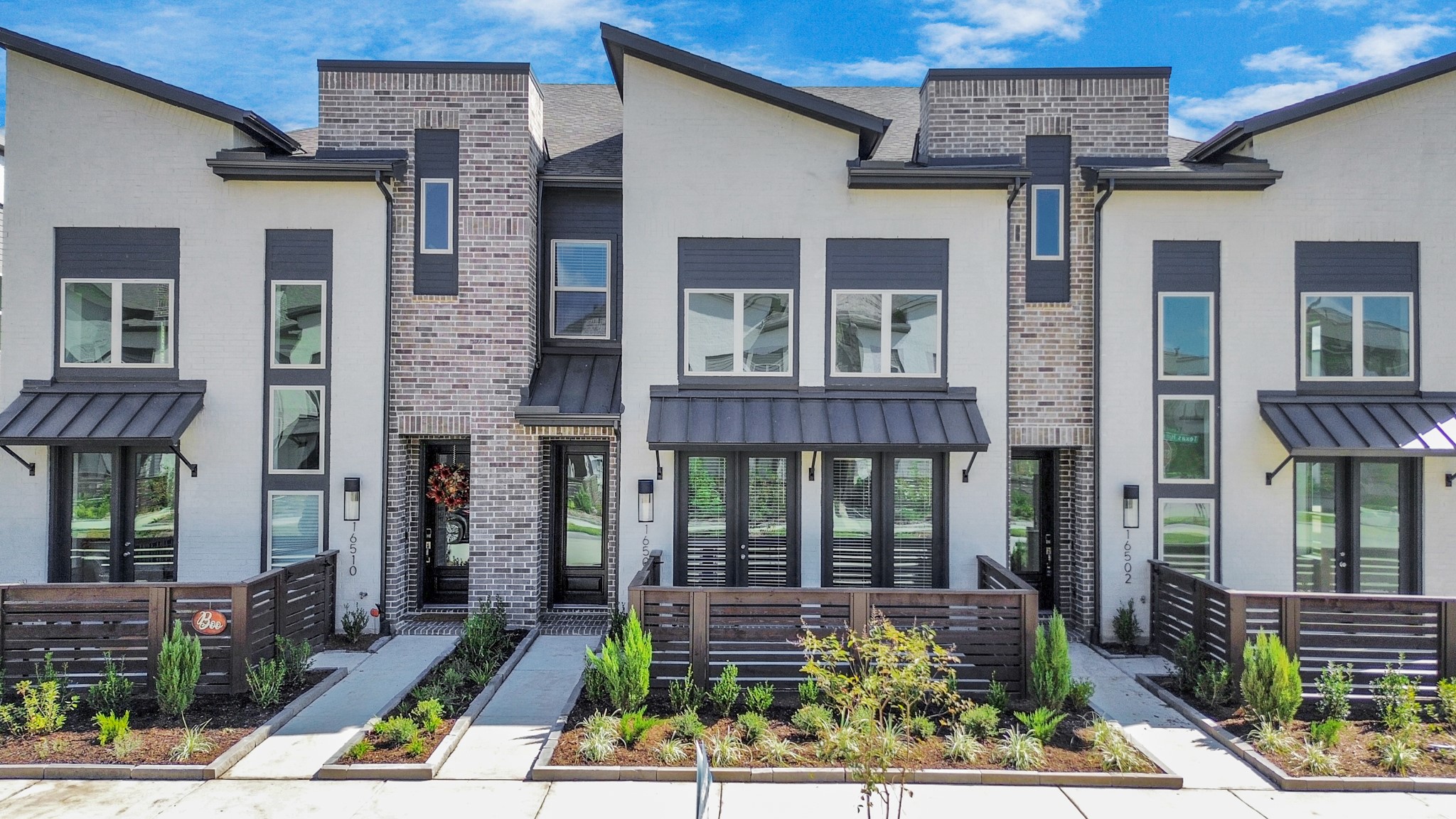 This modern townhome features sleek architecture, large windows, and a stylish entryway, blending elegance with contemporary design.