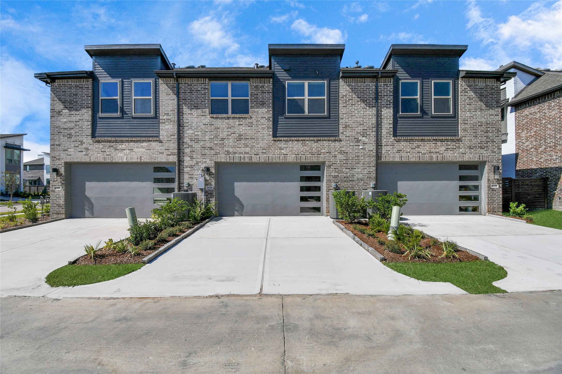 The back of the townhome showcases a stylish garage, seamlessly integrated into the modern design and enhancing the overall curb appeal.