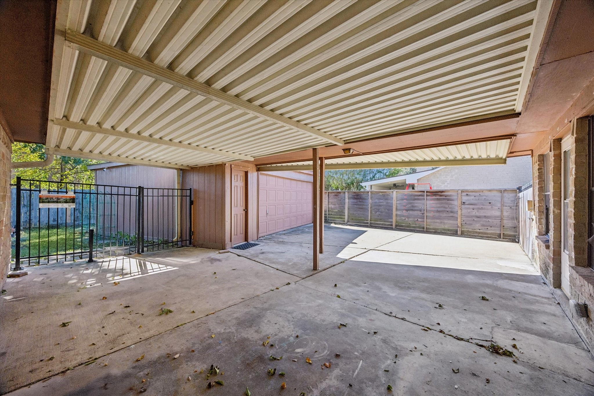 Spacious covered patio with sturdy metal roofing.