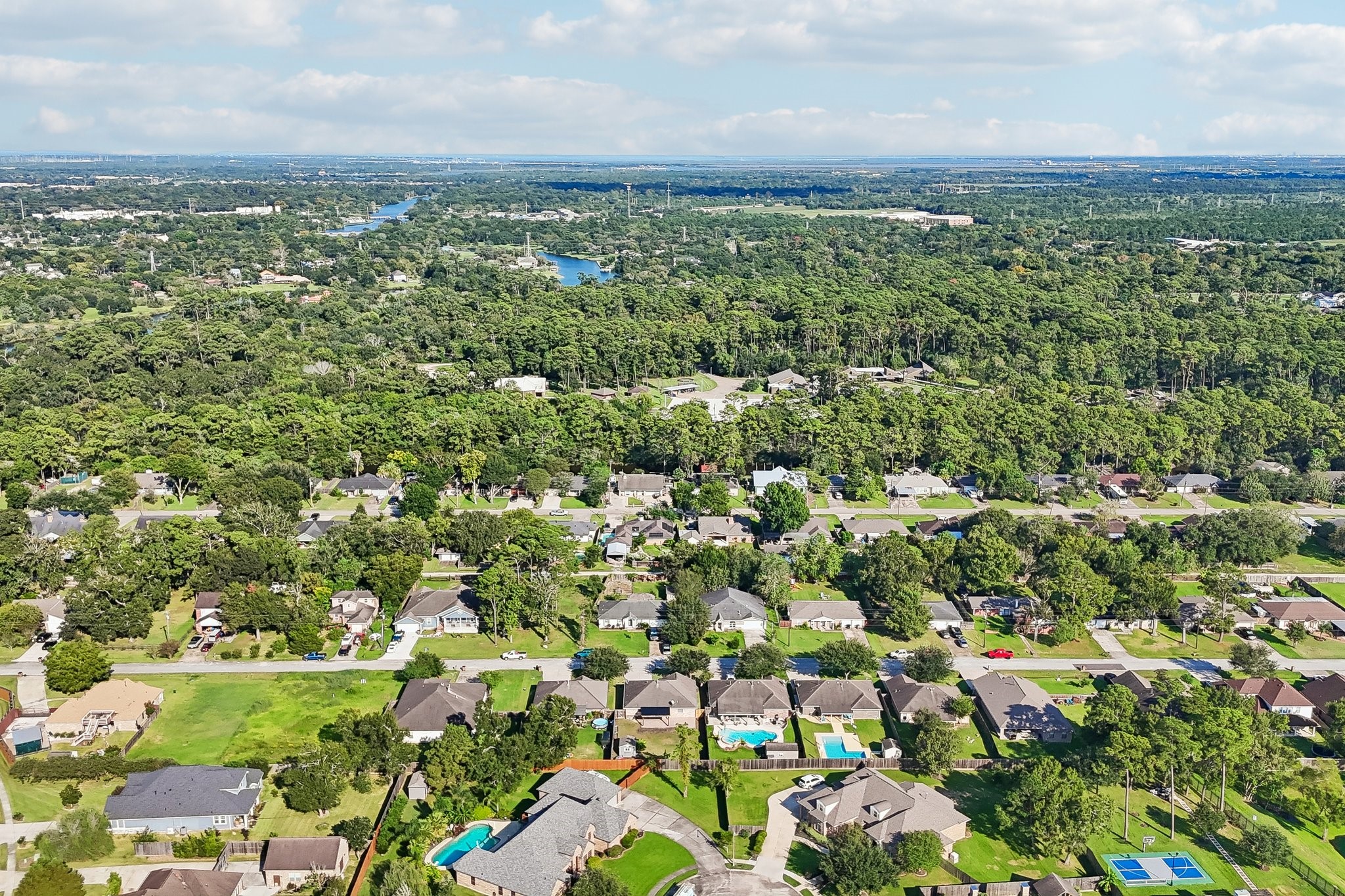 Charming suburban neighborhood with lush greenery, spacious homes, and inviting pools, offering a serene and picturesque setting.